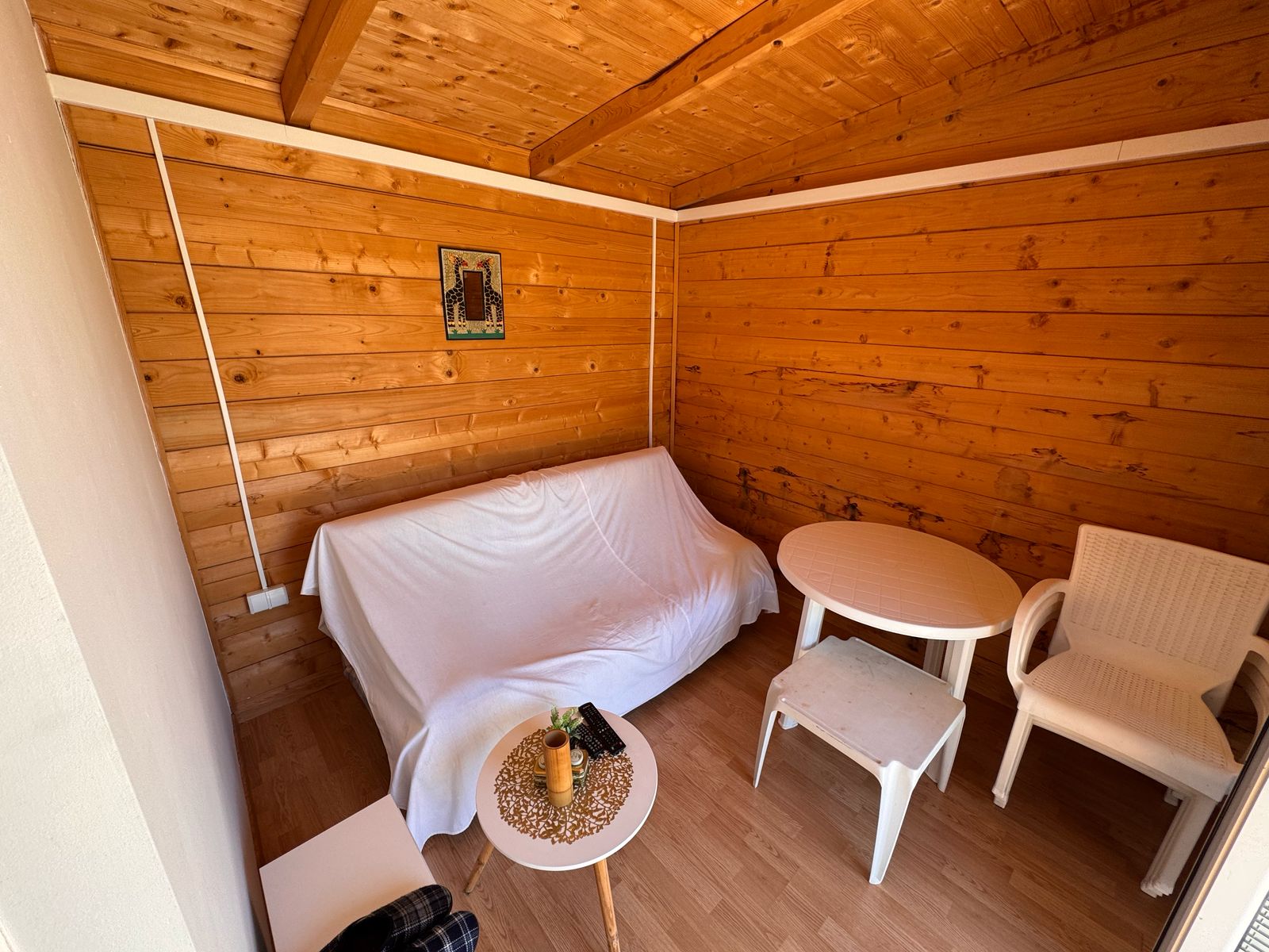 Charming Ulcinj property for sale: sunlit wooden room, stylish furnishings, exclusive on immobilien.ekosphere.me by Ekosphere DOO.