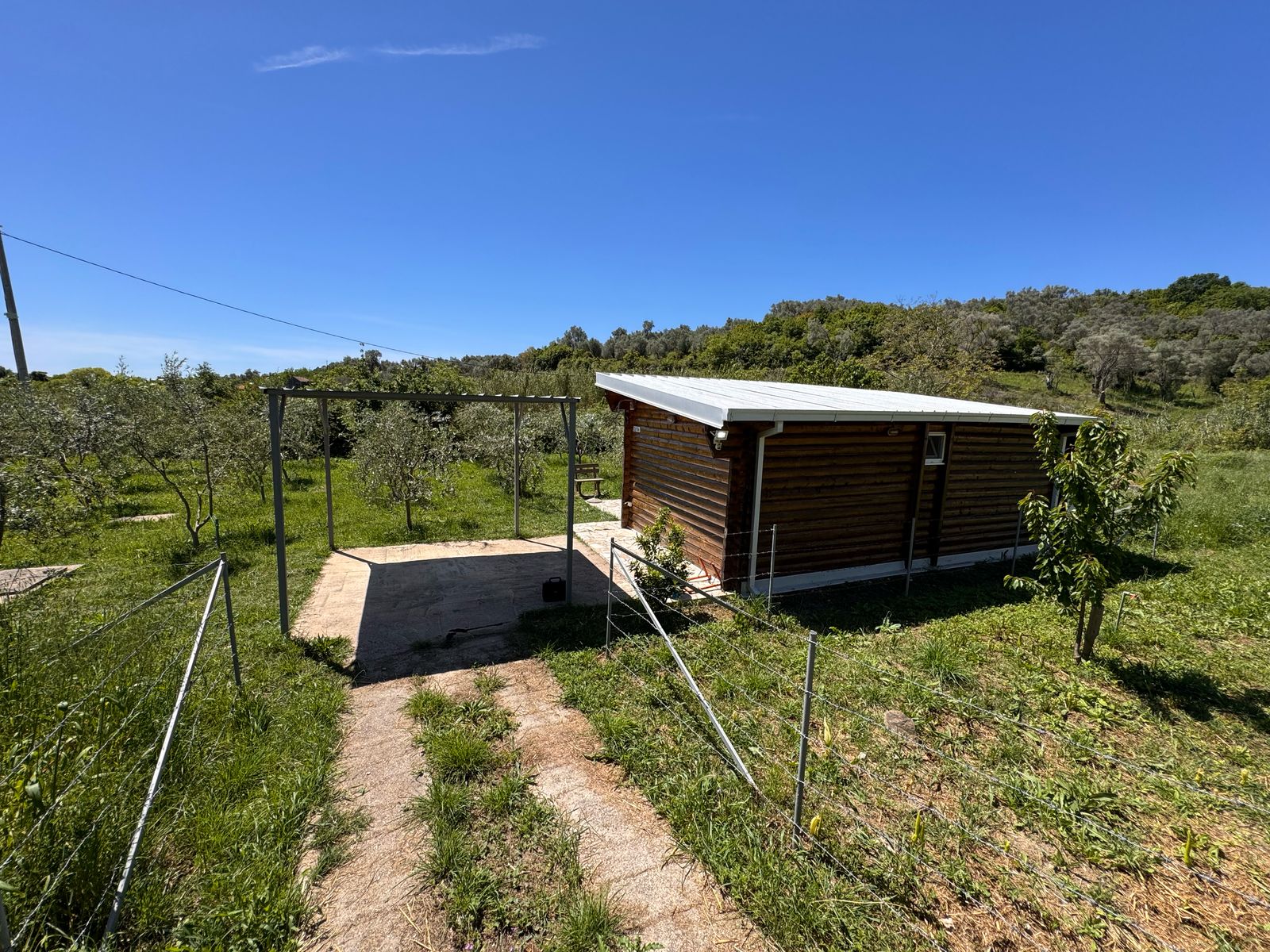 Charming wooden cabin with metal roof, lush grounds & modern path in Ulcinj&mdash;prime investment at immobilien.ekosphere.me by Ekosphere DOO.