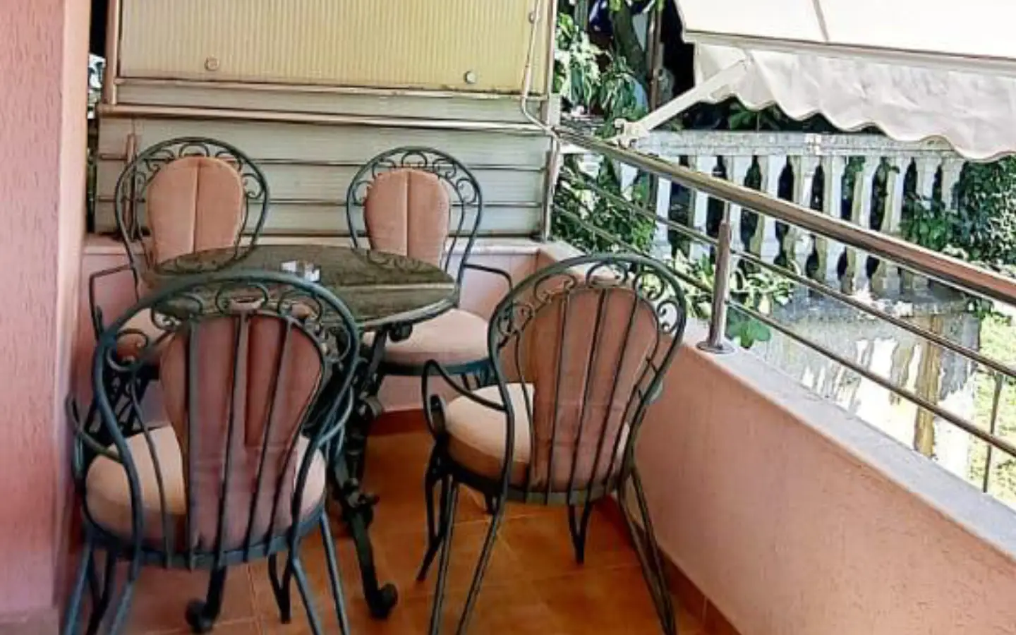 Elegant Ulcinj balcony with stone table, cushioned chairs, tiled floor, lush greenery&mdash;ideal property at immobilien.ekosphere.me by ekosphere doo.