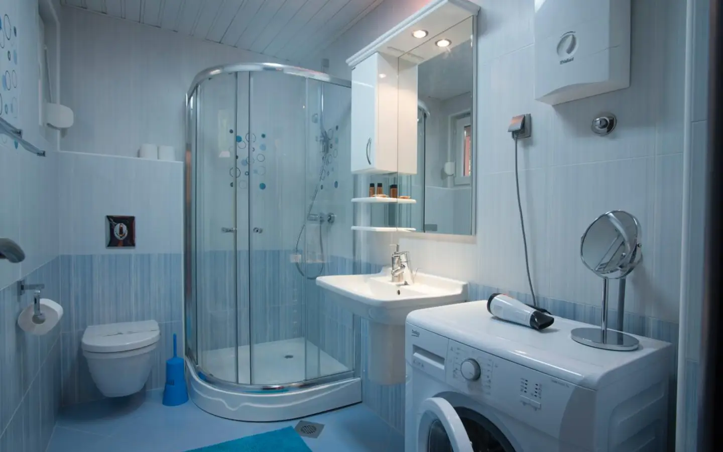 Contemporary Ulcinj bathroom: glass shower, modern fixtures, washing machine. Invest in Montenegro with immobilien.ekosphere.me by ekosphere doo.