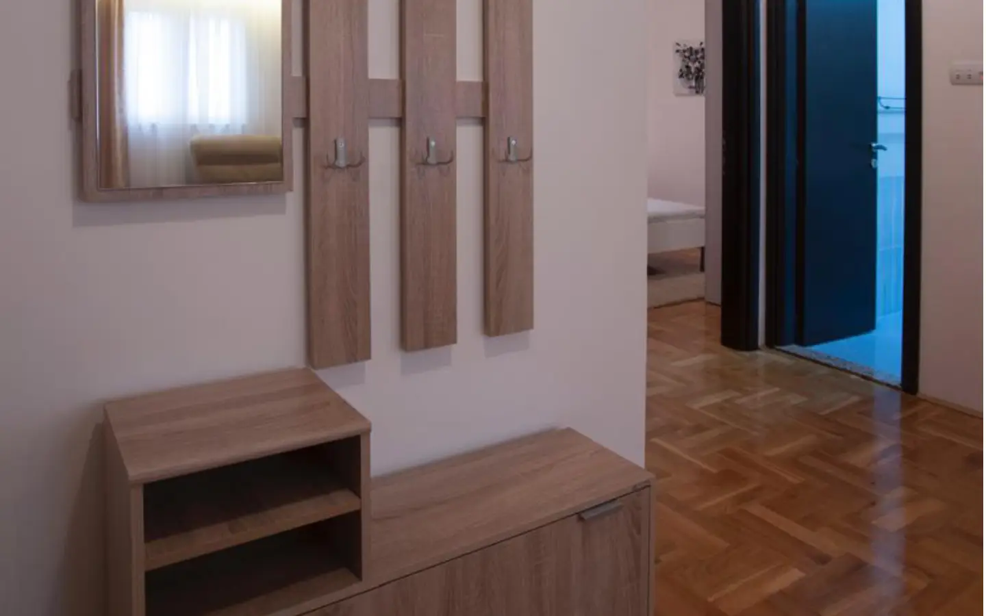 Elegant Ulcinj hallway with parquet floors, mirror, storage&mdash;ideal for property investment. Explore at immobilien.ekosphere.me by ekosphere doo.
