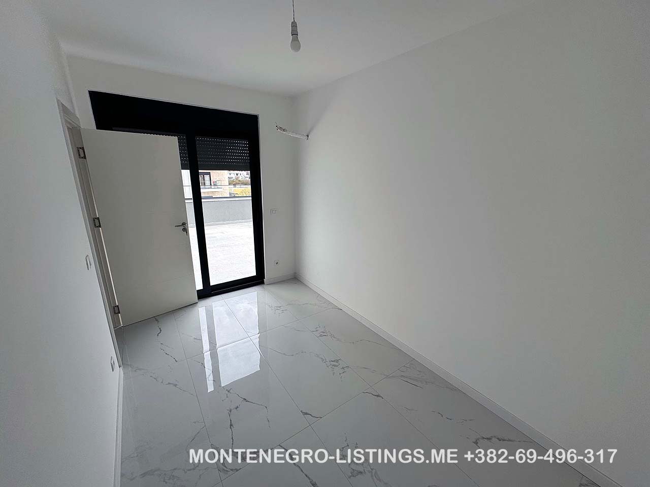 Bright, modern room in Ulcinj featuring white walls, marble tile, large window. Listed on immobilien.ekosphere.me by ekosphere doo.