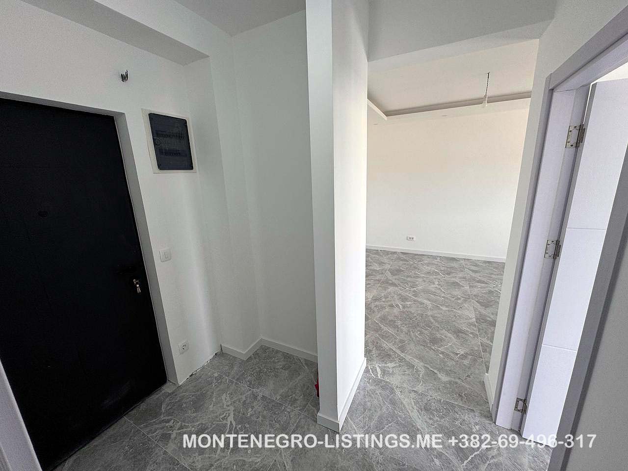 Contemporary interior in Ulcinj: gray tiled floors, white walls, bright open space. Invest with immobilien.ekosphere.me by ekosphere doo.