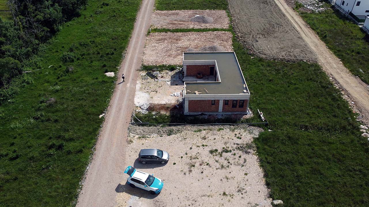 Prime aerial view of an unfinished brick property on spacious land in Ulcinj, Montenegro&mdash;ideal for investors via immobilien.ekosphere.me.