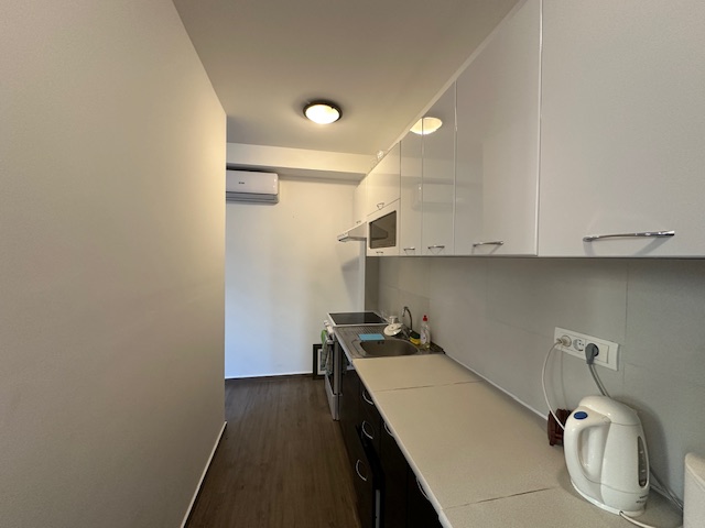 Modern kitchen in Ulcinj property: sleek white and dark cabinets, full appliances, air conditioning. Invest via immobilien.ekosphere.me by ekosphere doo.