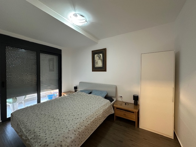 Modern Ulcinj property with a stylish bed, two wooden nightstands, large windows; exclusive listing by immobilien.ekosphere.me ekosphere doo.