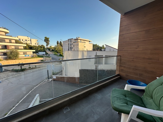 Modern balcony with glass railing, stylish seating and table, overlooking prime Ulcinj real estate&mdash;Exclusive at immobilien.ekosphere.me by Ekosphere DOO.