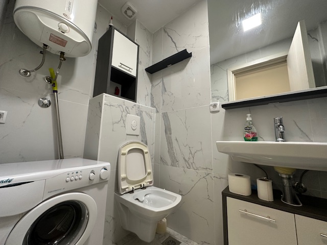 Modern Ulcinj bathroom with washer, heater, marble tiles&mdash;smart real estate investment by Ekosphere on immobilien.ekosphere.me.