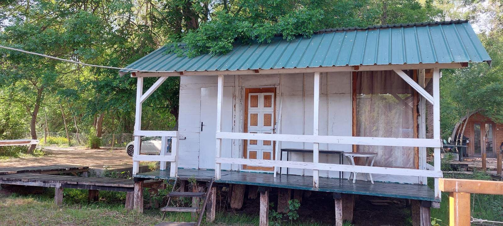 Eco-friendly wooden cabin with green roof and white features on raised deck; prime Ulcinj real estate by immobilien.ekosphere.me/Ekosphere.