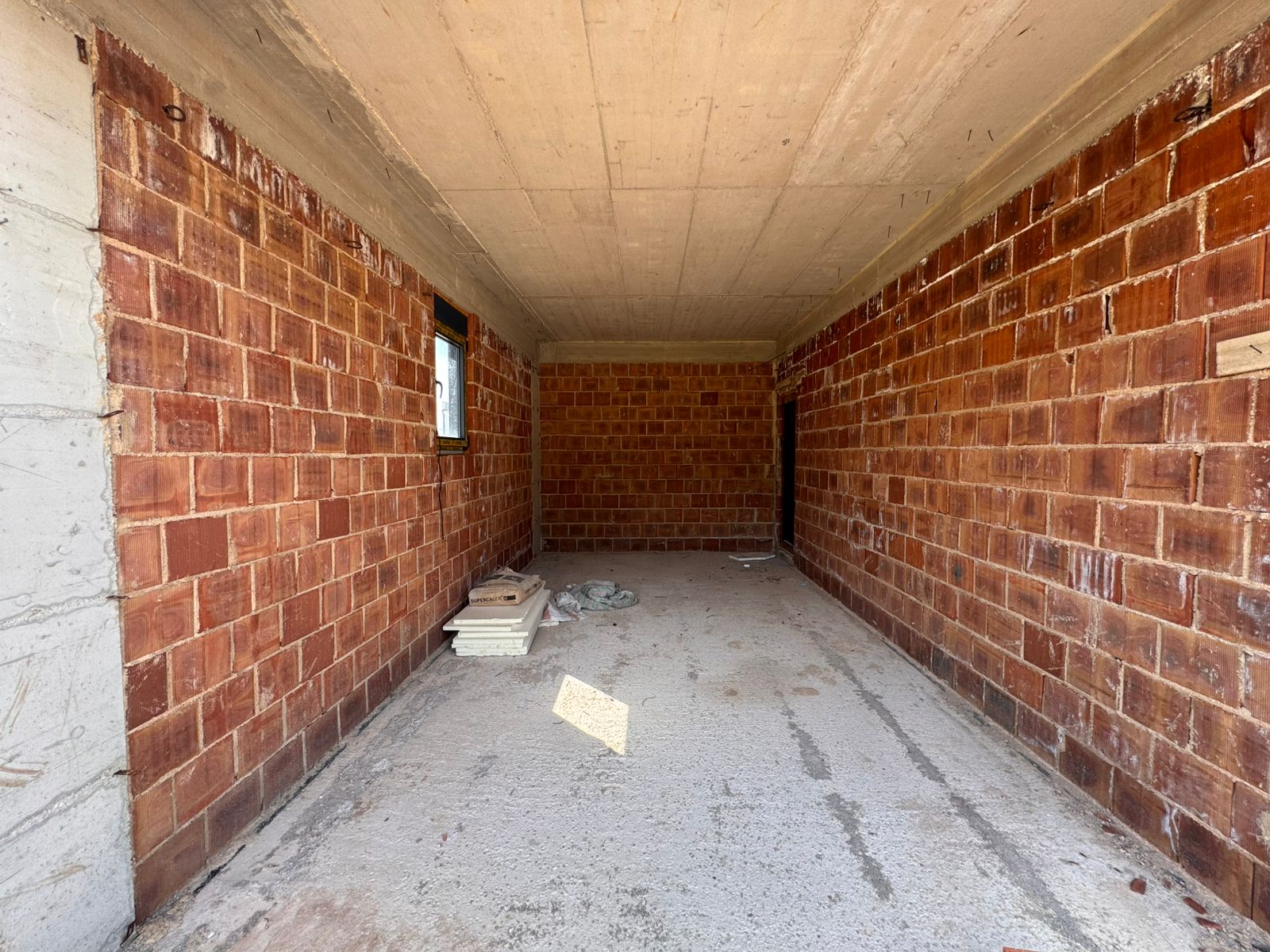 Spacious unfinished brick room with concrete floor, window, prime Ulcinj real estate&mdash;investment via immobilien.ekosphere.me by ekosphere doo.