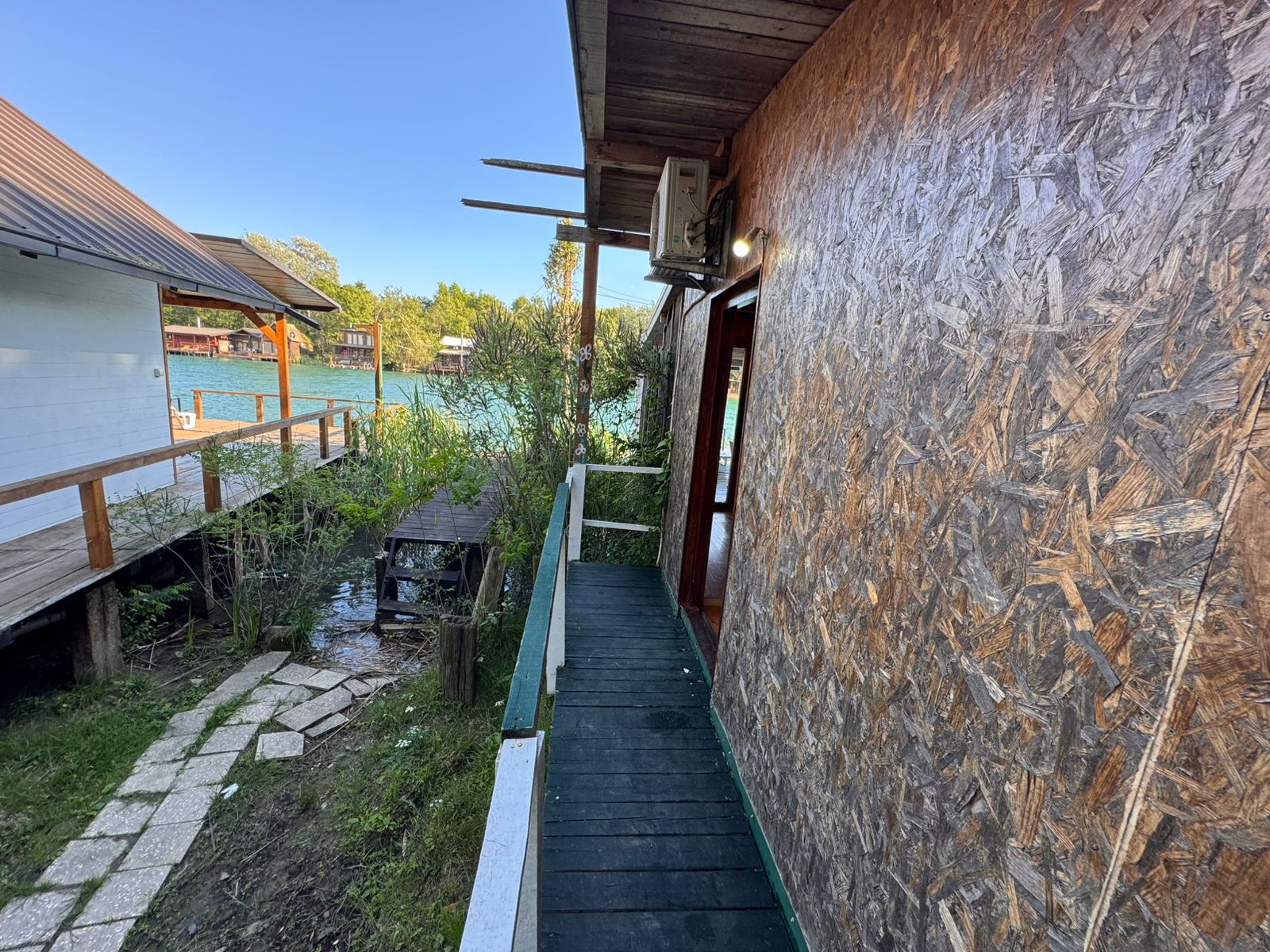 Discover investment potential in Ulcinj: modern Ekosphere property with wooden walkway, scenic greenery, and waterfront views&mdash;immobilien.ekosphere.me.