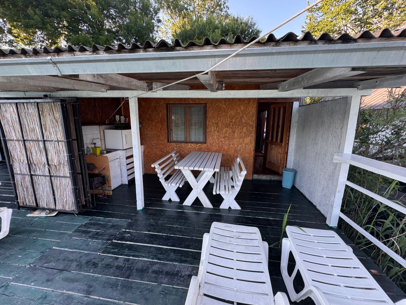 Charming covered patio with elegant white furniture, lounge chairs, and wooden accents&mdash;exclusive Ulcinj real estate by Ekosphere on immobilien.ekosphere.me.