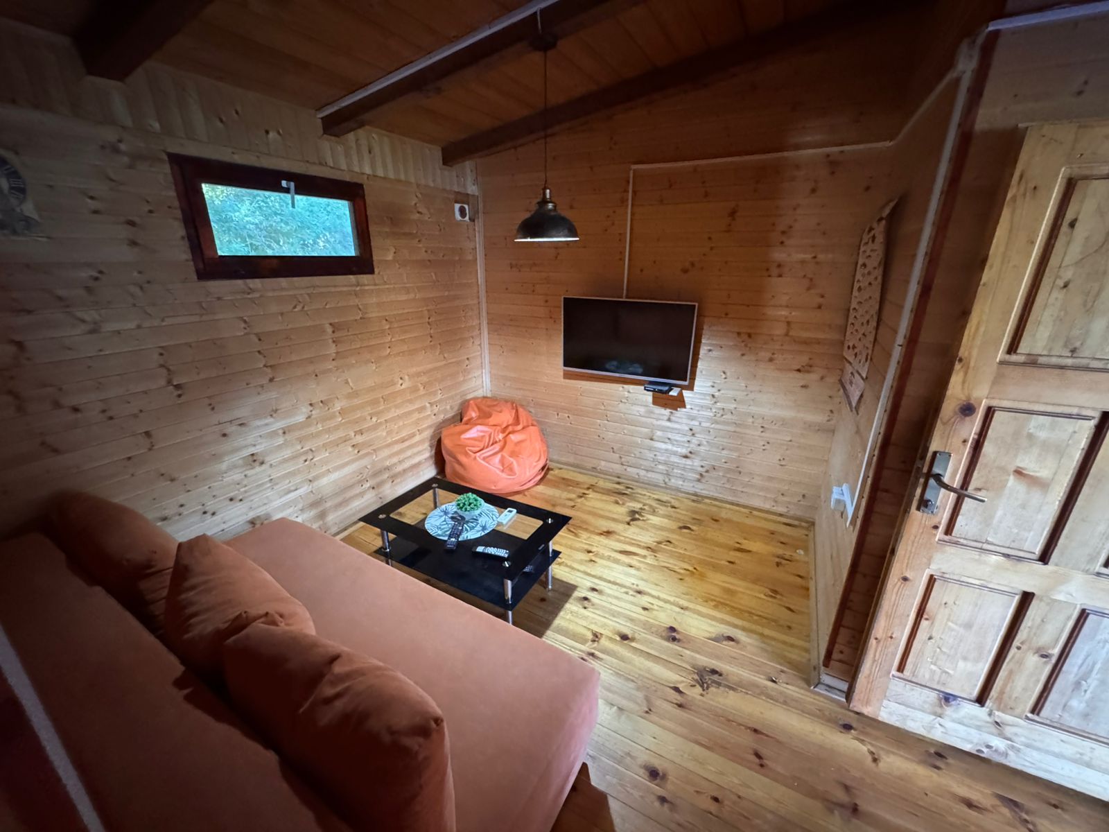 Stylish wooden room in Ulcinj: sofa, coffee table, TV. Unique real estate by ekosphere doo&mdash;find properties on immobilien.ekosphere.me.