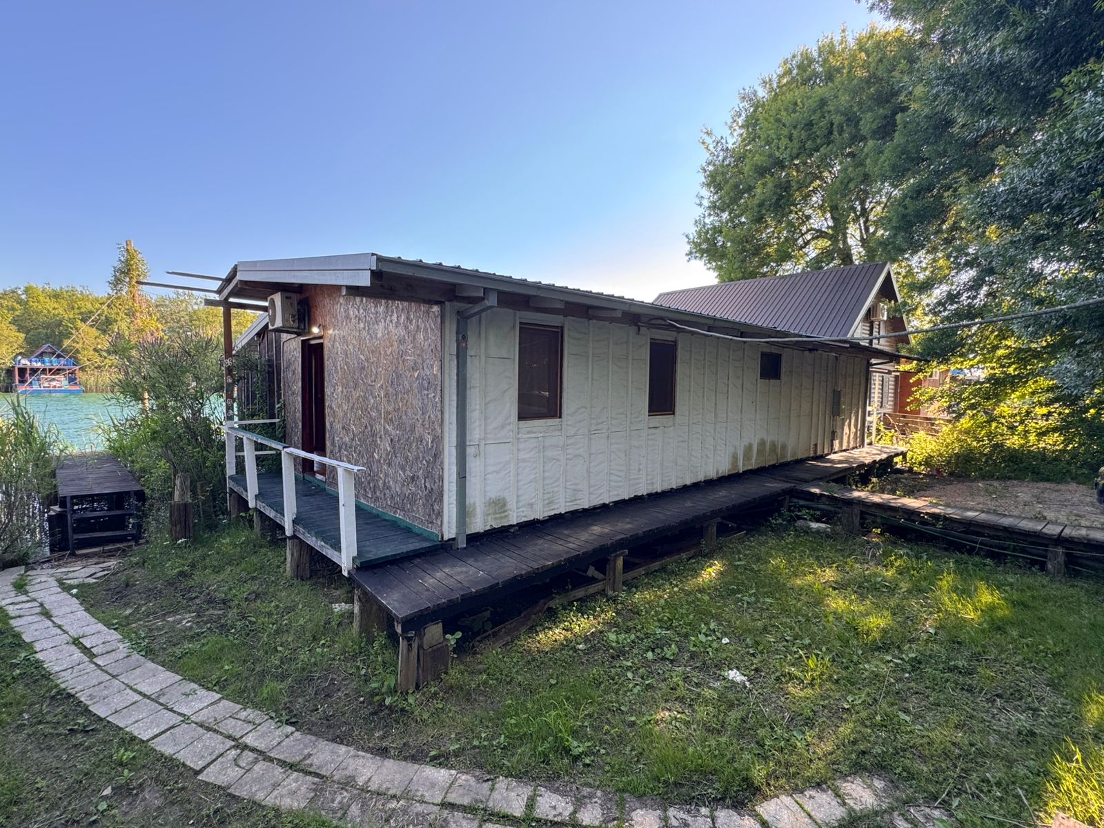 Premium opportunity: Modern rectangular building with metal roof, white siding, ramp, in lush Ulcinj. Invest via immobilien.ekosphere.me by ekosphere doo.