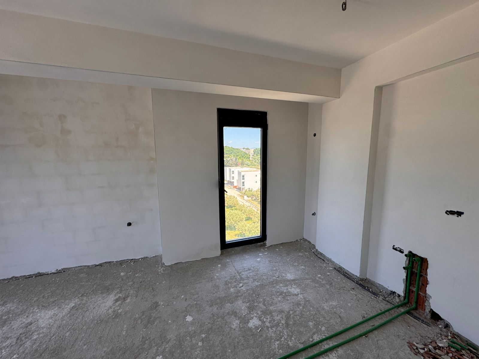 Unfinished Ulcinj property with concrete floors, white walls, and city views&mdash;exclusive on immobilien.ekosphere.me by Ekosphere doo.