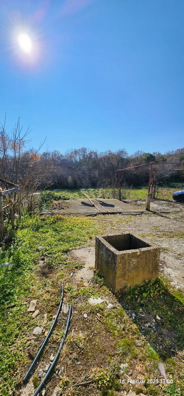 Prime Ulcinj property: spacious sunlit yard with concrete well, lush greenery&mdash;ideal for investment. Listed by immobilien.ekosphere.me, an ekosphere doo project.