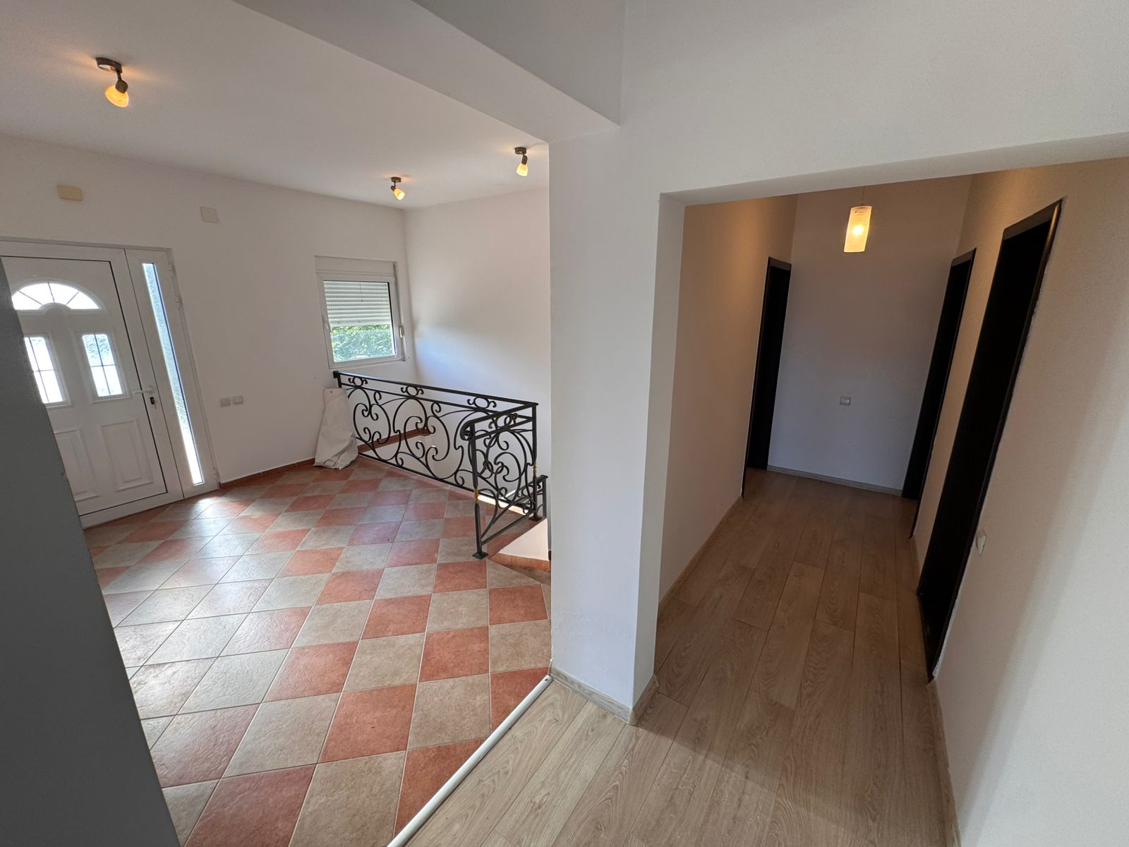 Sunlit entryway with tiled floor, elegant railings, and wood-floored hallway&mdash;prime Ulcinj real estate by immobilien.ekosphere.me/Ekosphere doo.