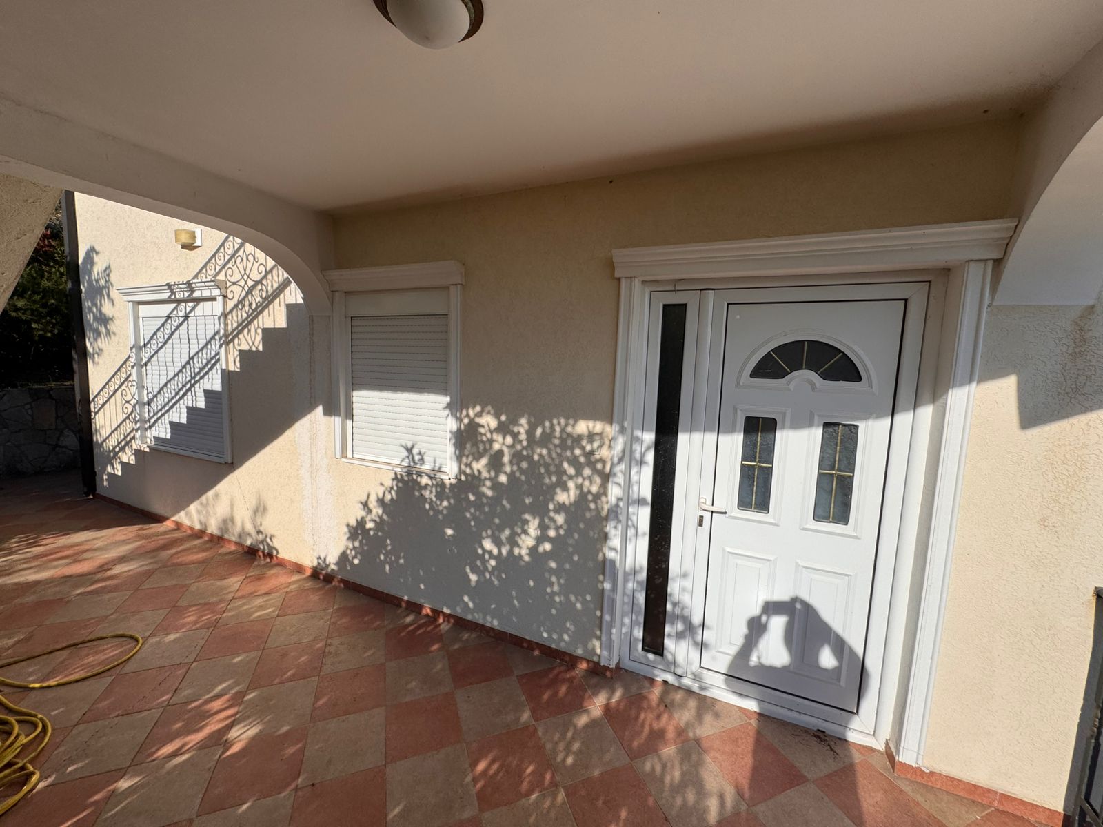 Modern white front door with glass panel and tiled entry, ideal Ulcinj real estate by ekosphere doo via immobilien.ekosphere.me.