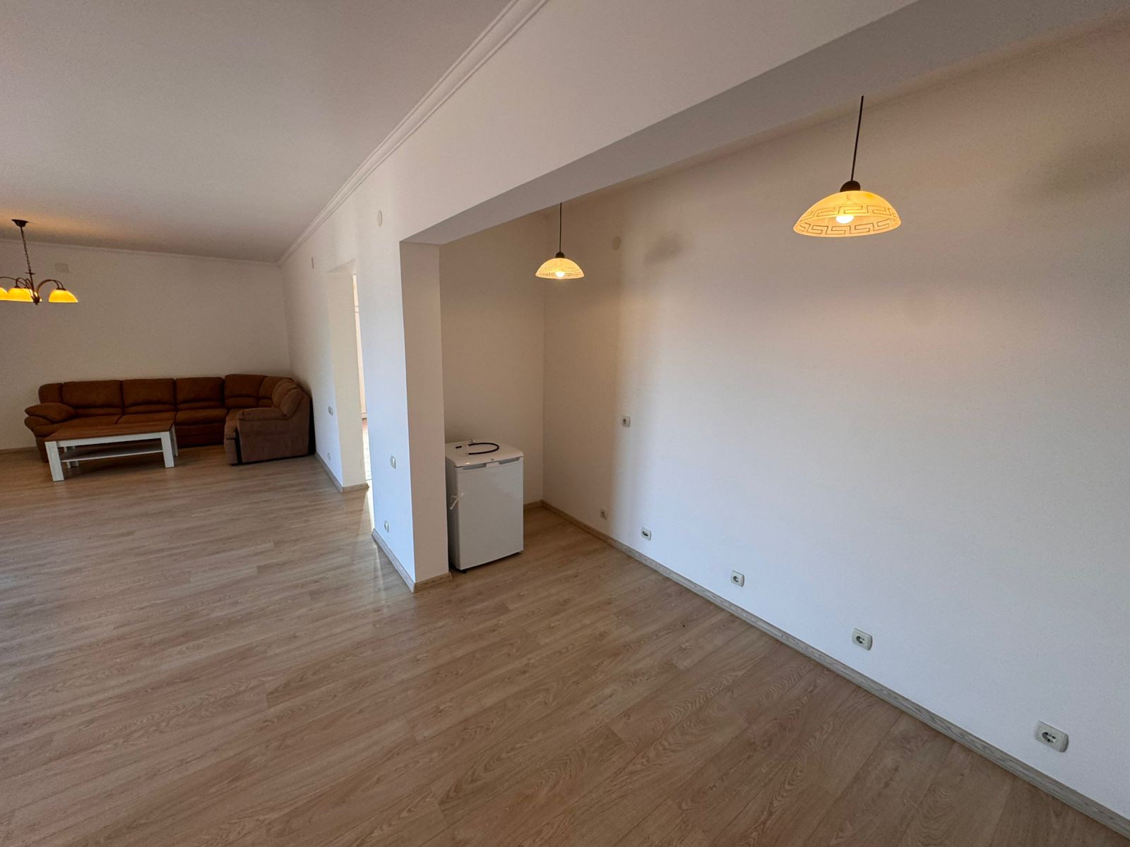 Spacious unfurnished room in Ulcinj with light wood floors, white walls, modern lighting; ideal Montenegro investment by ekosphere doo.