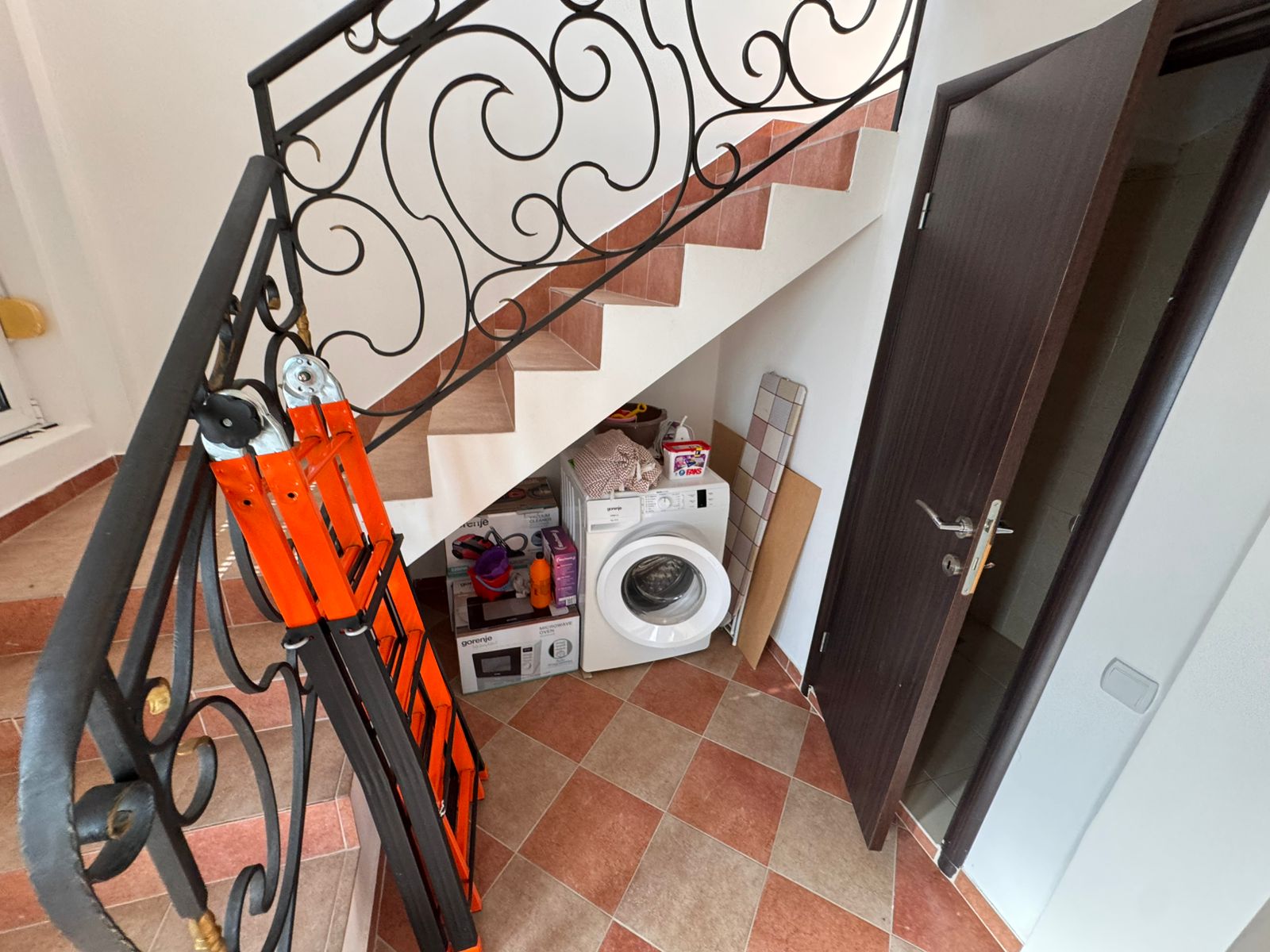 Modern under-stair laundry in Ulcinj Montenegro property: washing machine, storage, tile floor&mdash;exclusive on immobilien.ekosphere.me by ekosphere doo.