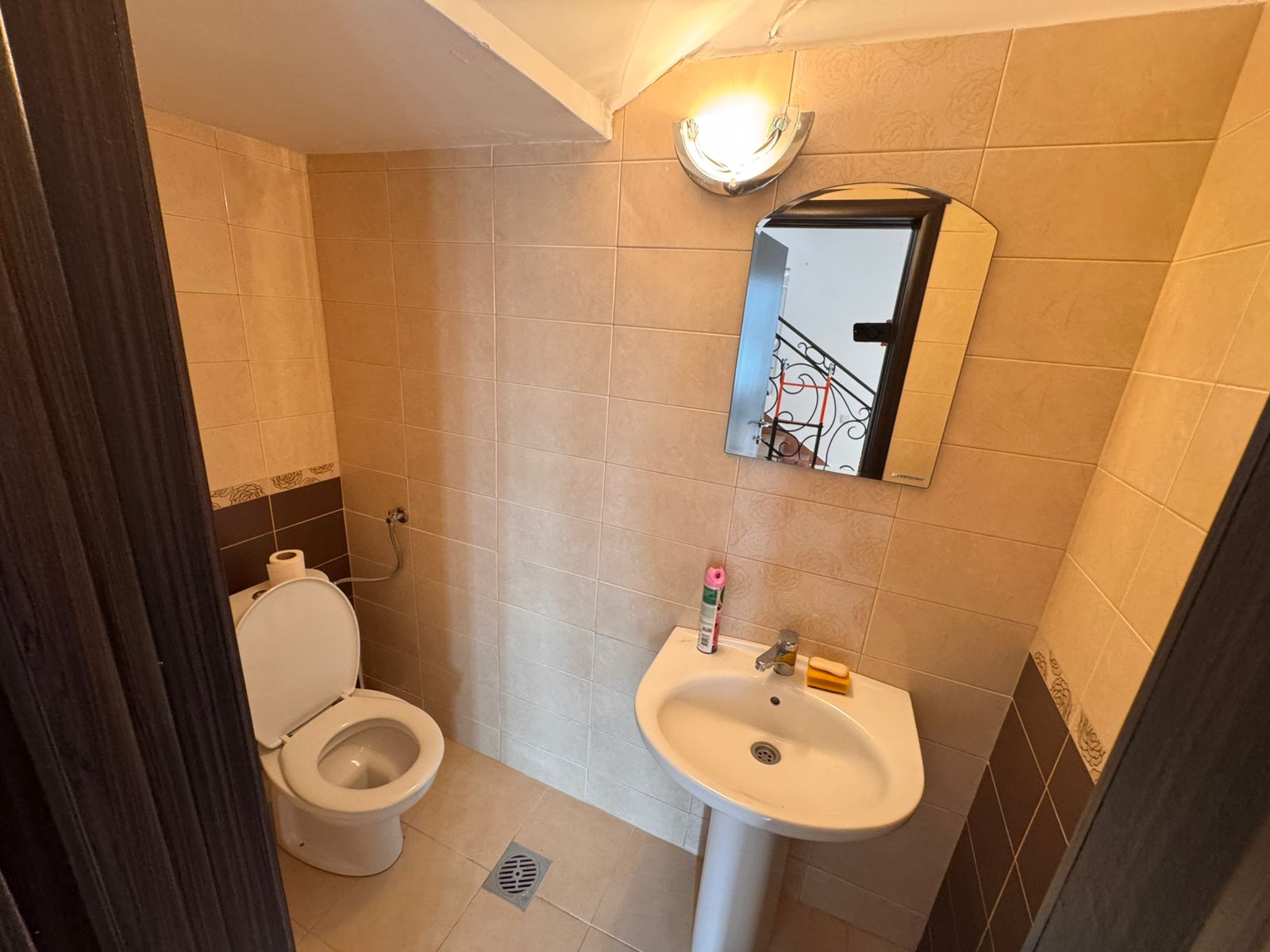 Modern bathroom in Ulcinj, Montenegro property&mdash;beige tiles, white fixtures, mirror with lighting. Exclusive listing on immobilien.ekosphere.me by ekosphere doo.