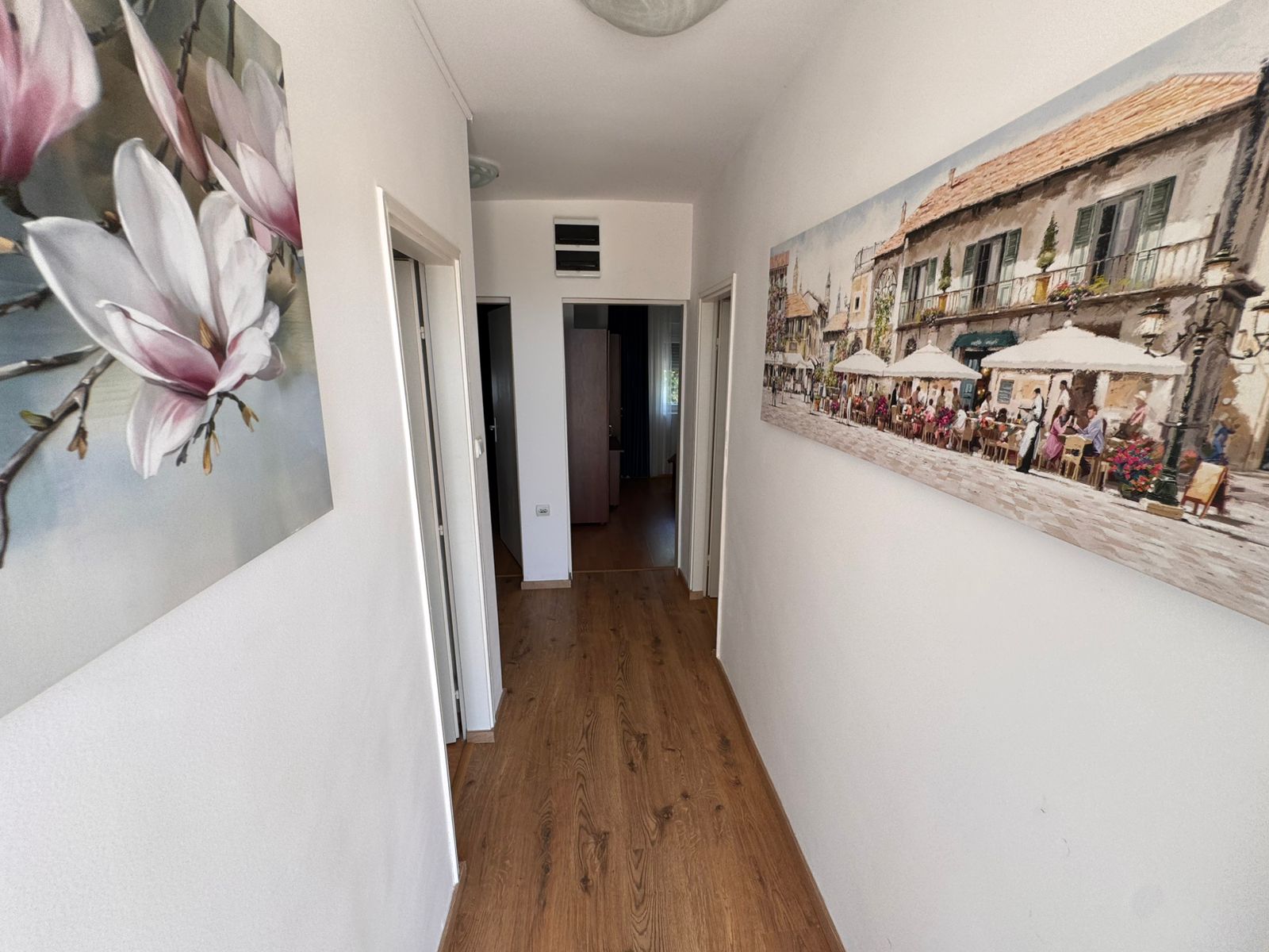 Elegant hallway in Ekosphere, Ulcinj: wood floors, bright walls, art accents, sunlit&mdash;prime Montenegro property on immobilien.ekosphere.me.