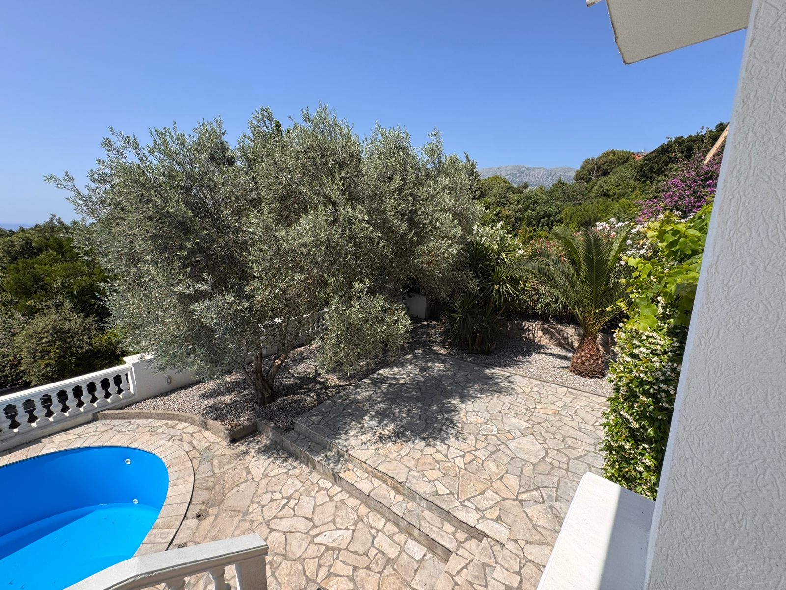 Premium Ulcinj property: stone patio, lush garden, pool & blue skies. Invest in Montenegro real estate with immobilien.ekosphere.me by ekosphere doo.