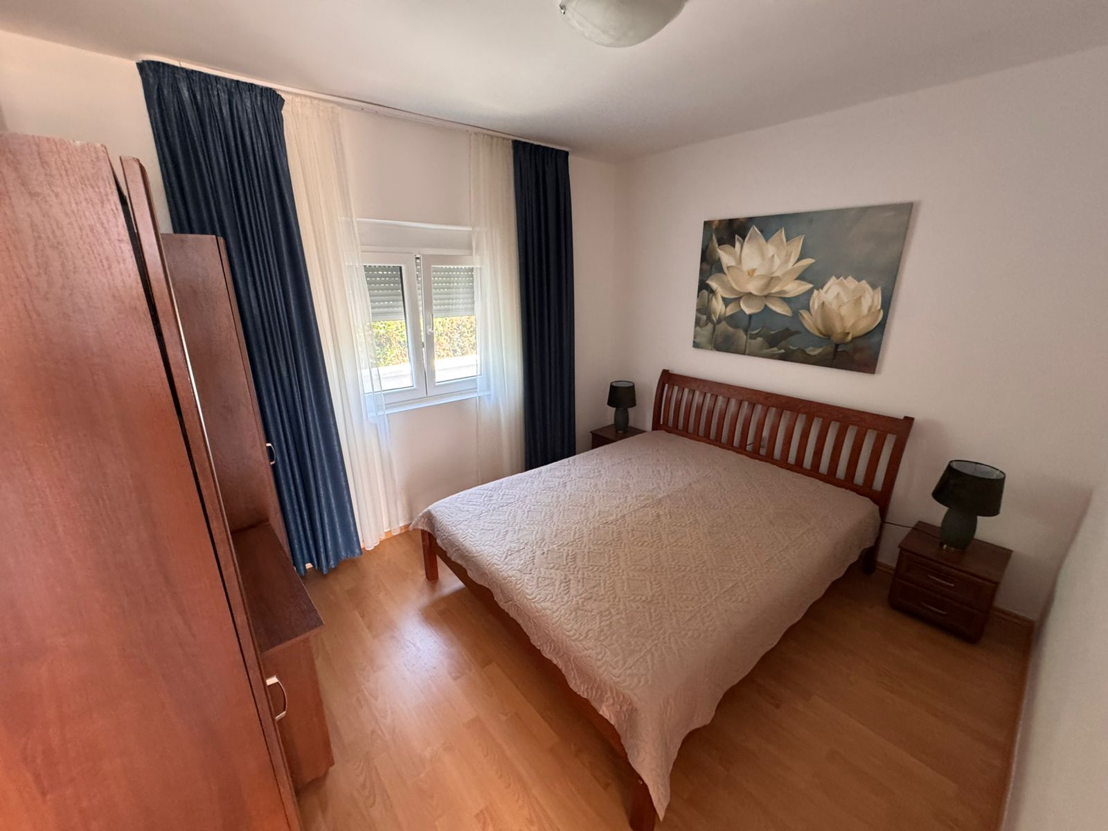 Elegant Ulcinj bedroom for sale: wood bed, luxe beige quilt, top finishes. Invest with Montenegro-listings.me by Ekosphere doo.