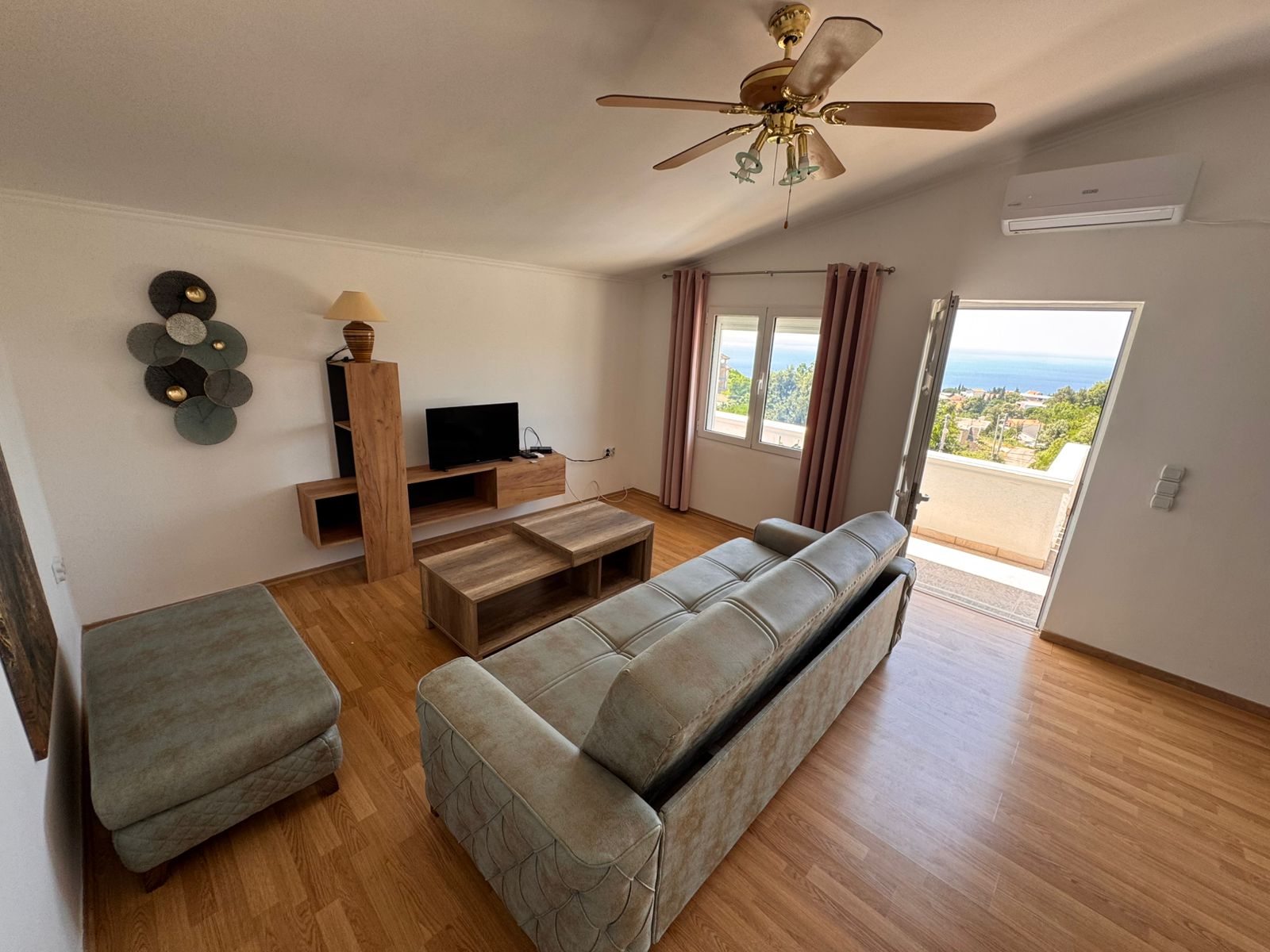Modern Ulcinj apartment: wood floors, cozy sofa, balcony with sea & green views. Prime investment via immobilien.ekosphere.me by ekosphere doo.