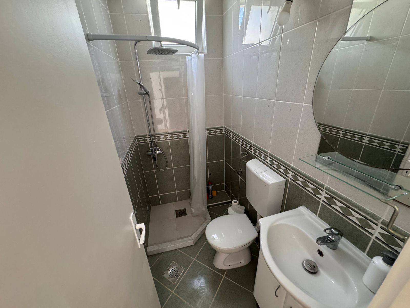 Modern small bathroom in Ulcinj property: tiled, corner shower, stylish fixtures. Invest via immobilien.ekosphere.me by Ekosphere doo.