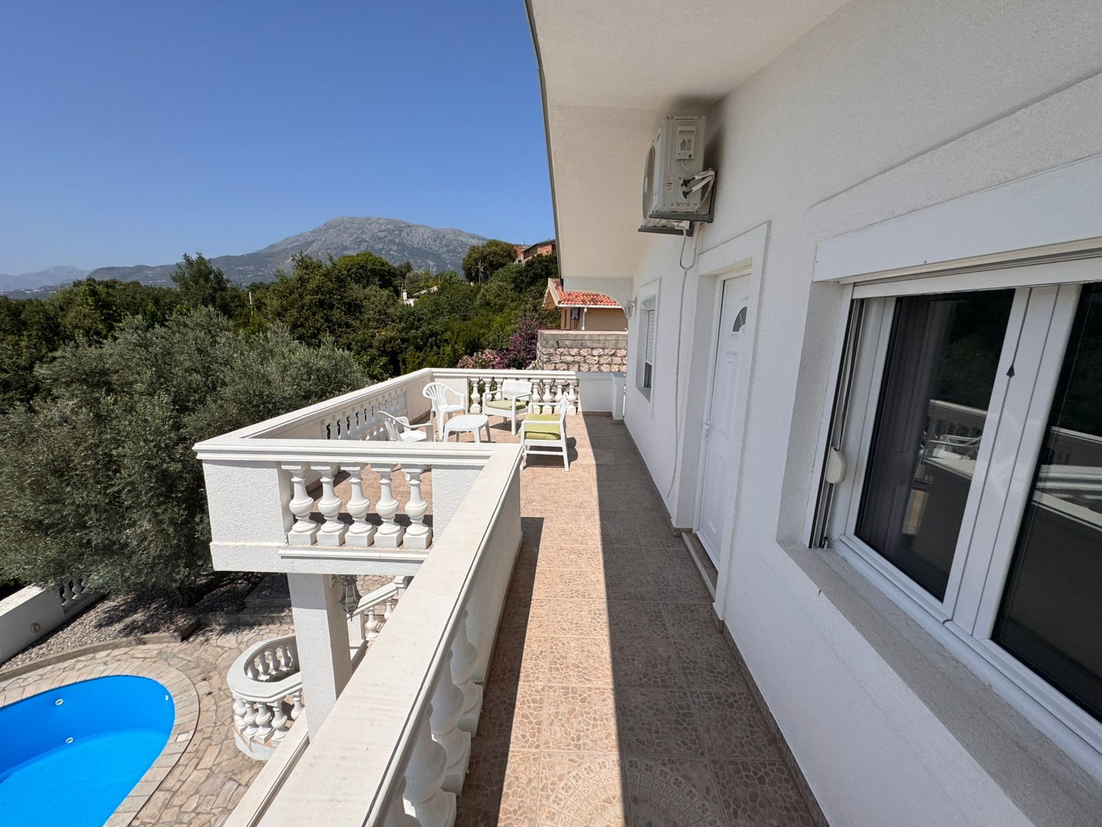 Elegant white balcony with tiled floor, pool view, scenic mountains&mdash;prime Ulcinj real estate by Ekosphere DOO at immobilien.ekosphere.me.