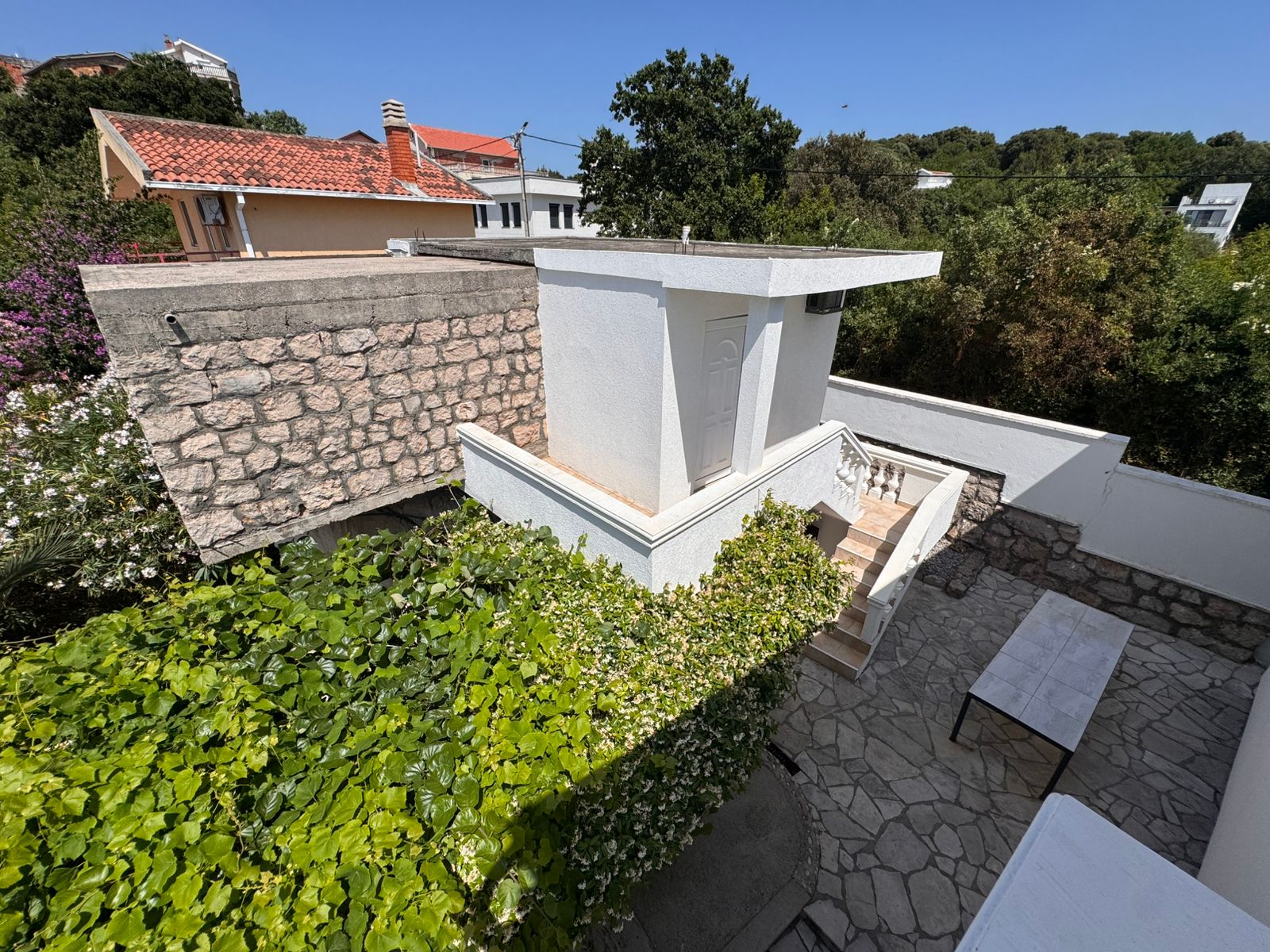 Charming white home in Ulcinj, Montenegro, with stone walls and lush greenery&mdash;ideal real estate investment at immobilien.ekosphere.me by ekosphere doo.