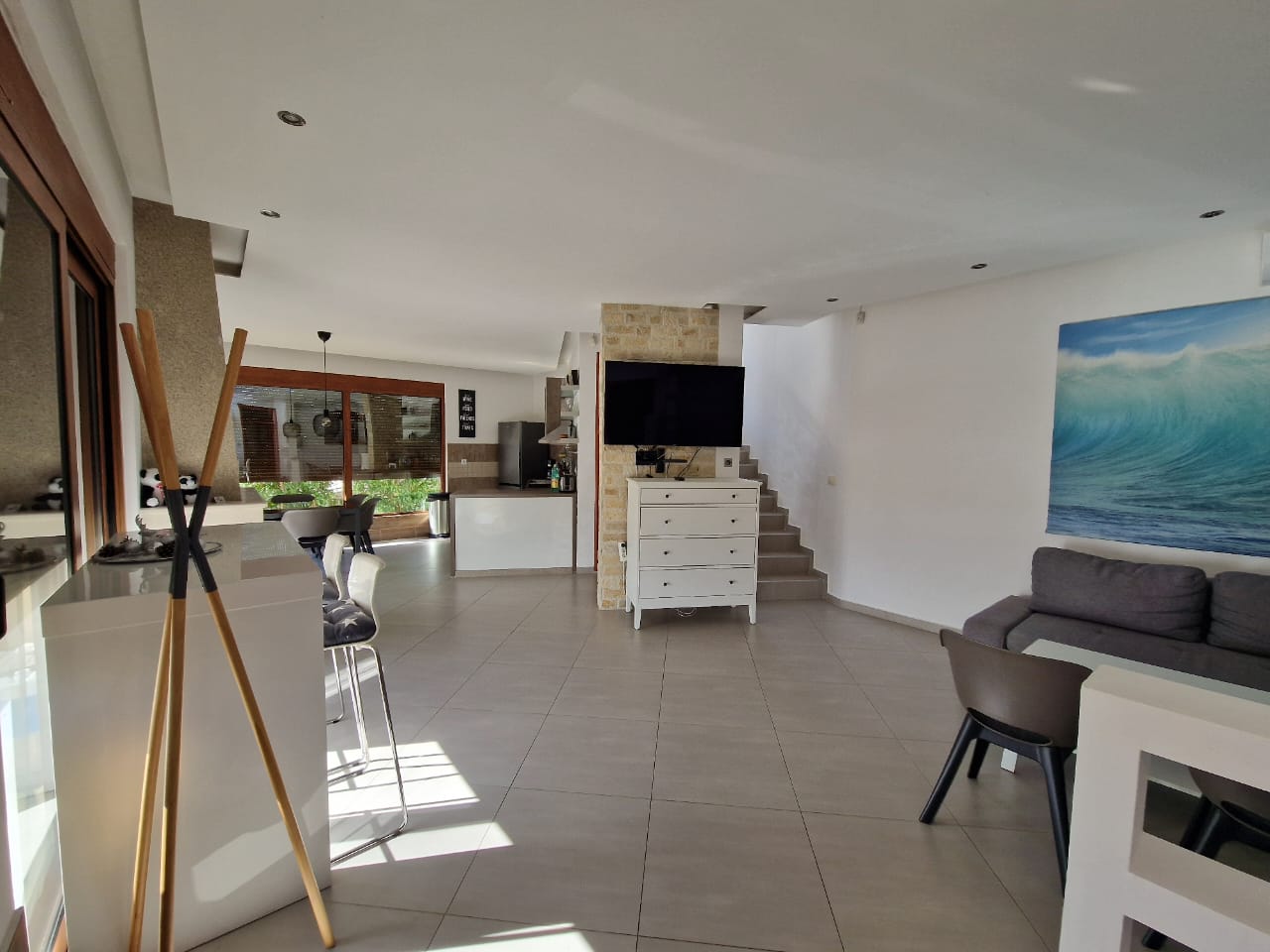 Stunning Ulcinj open-plan living: tiled floors, gray sectional, large windows. Prime investment by Ekosphere&mdash;immobilien.ekosphere.me.