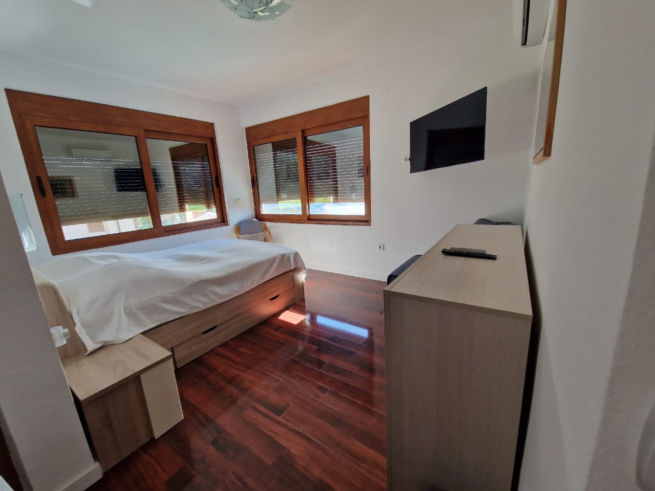 Modern Ulcinj bedroom with double bed, sleek furnishings & large windows&mdash;premium real estate by Ekosphere on immobilien.ekosphere.me.