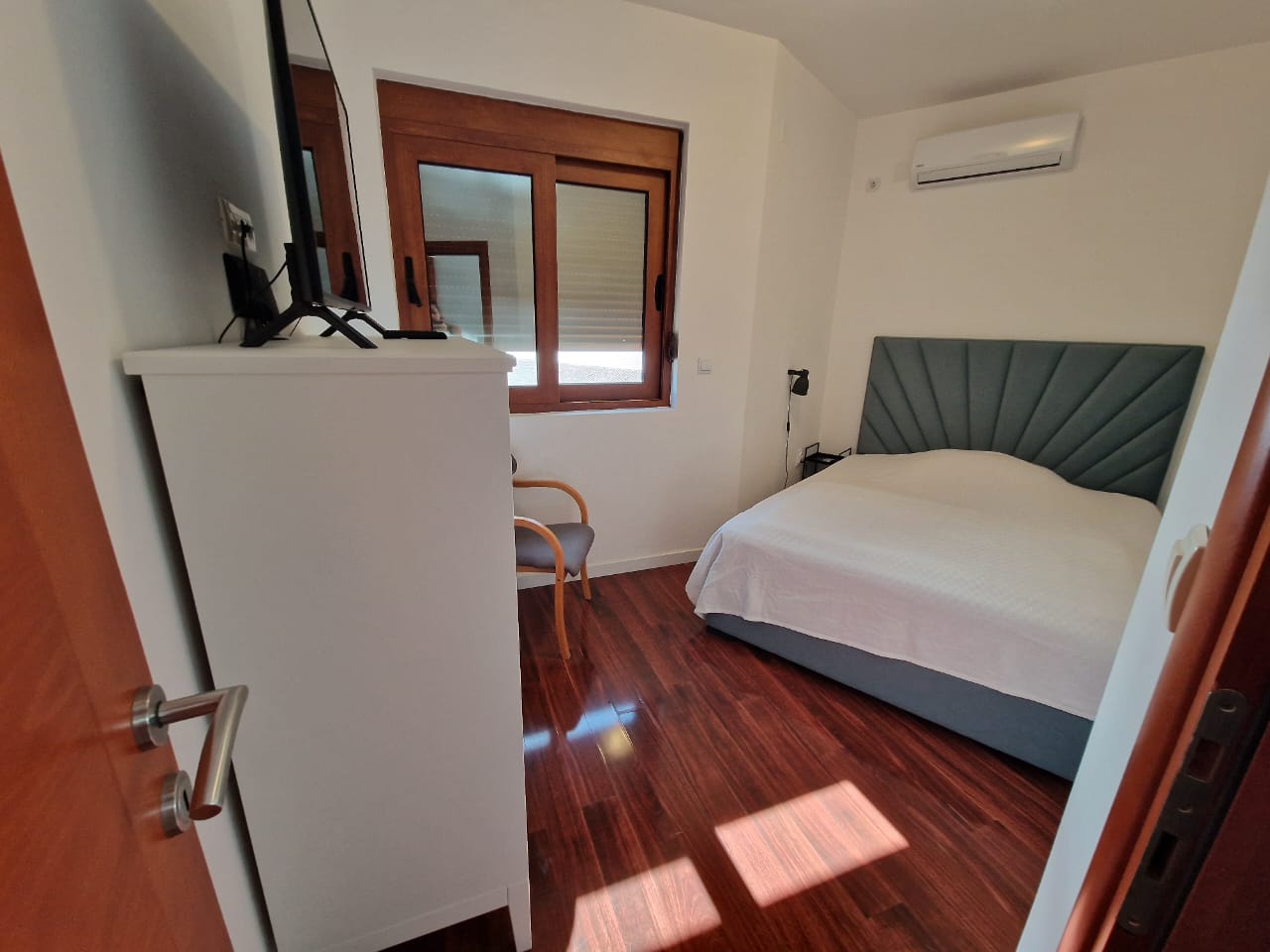 Stylish Ulcinj bedroom with double bed, wood floor, AC, and modern comforts&mdash;prime property by Ekosphere on immobilien.ekosphere.me.