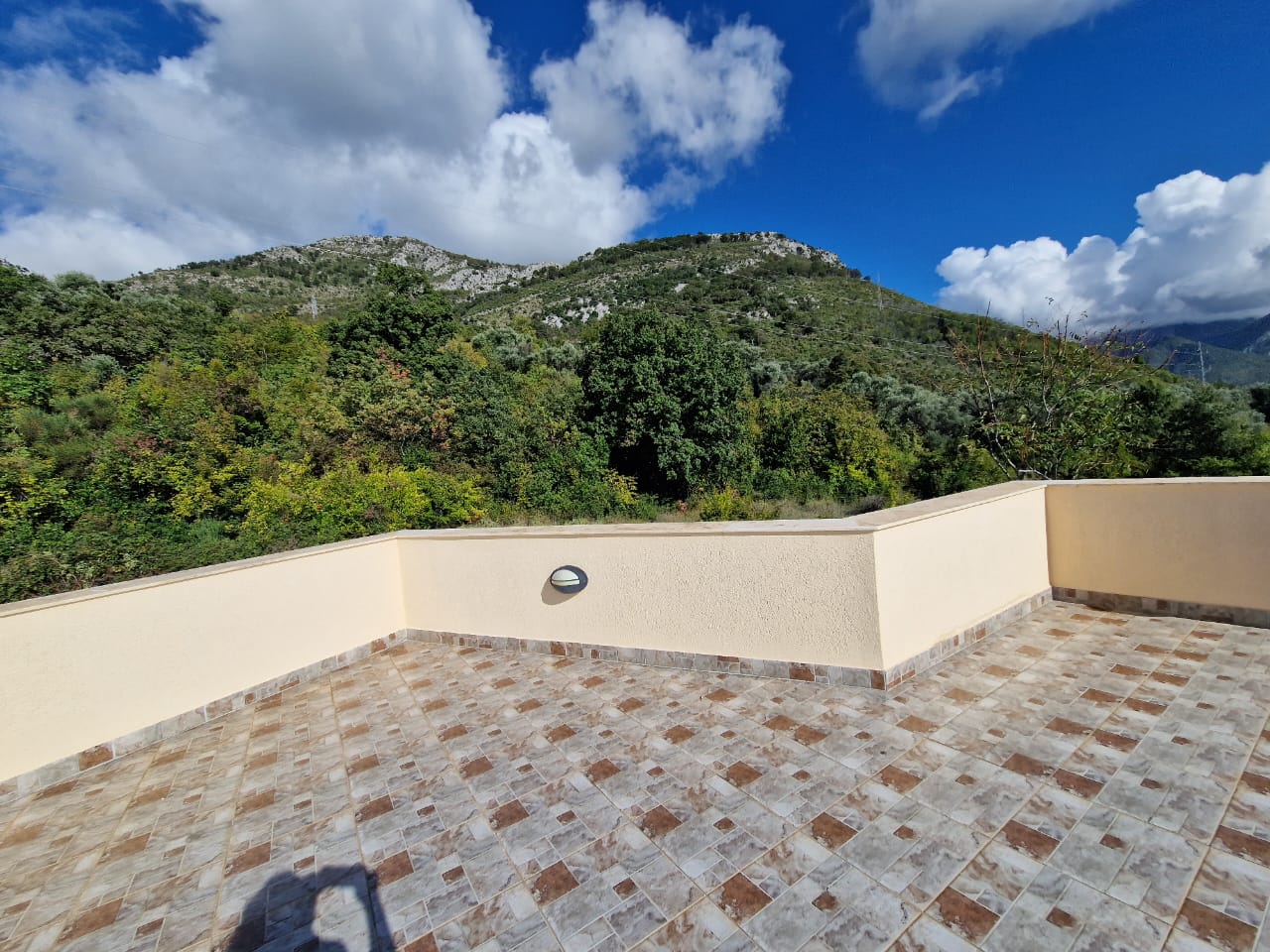 Spacious tiled terrace with beige walls in Ulcinj, Montenegro, boasting stunning green views&mdash;listed on immobilien.ekosphere.me by Ekosphere doo.