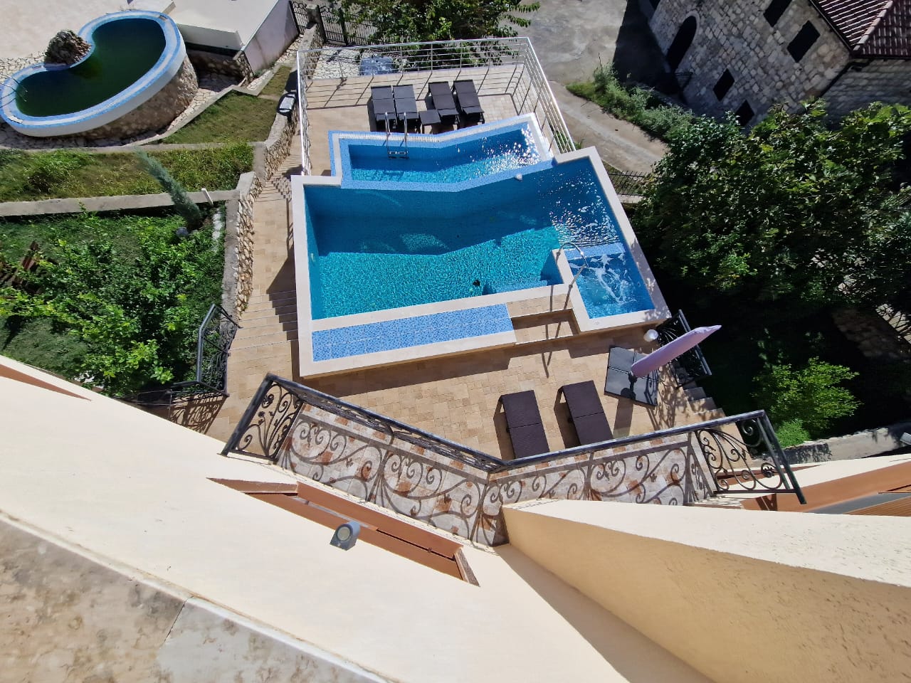 Stunning aerial view of Ulcinj villa: crystal-clear pool, elegant patio, lush Ekosphere greenery. Invest at immobilien.ekosphere.me.
