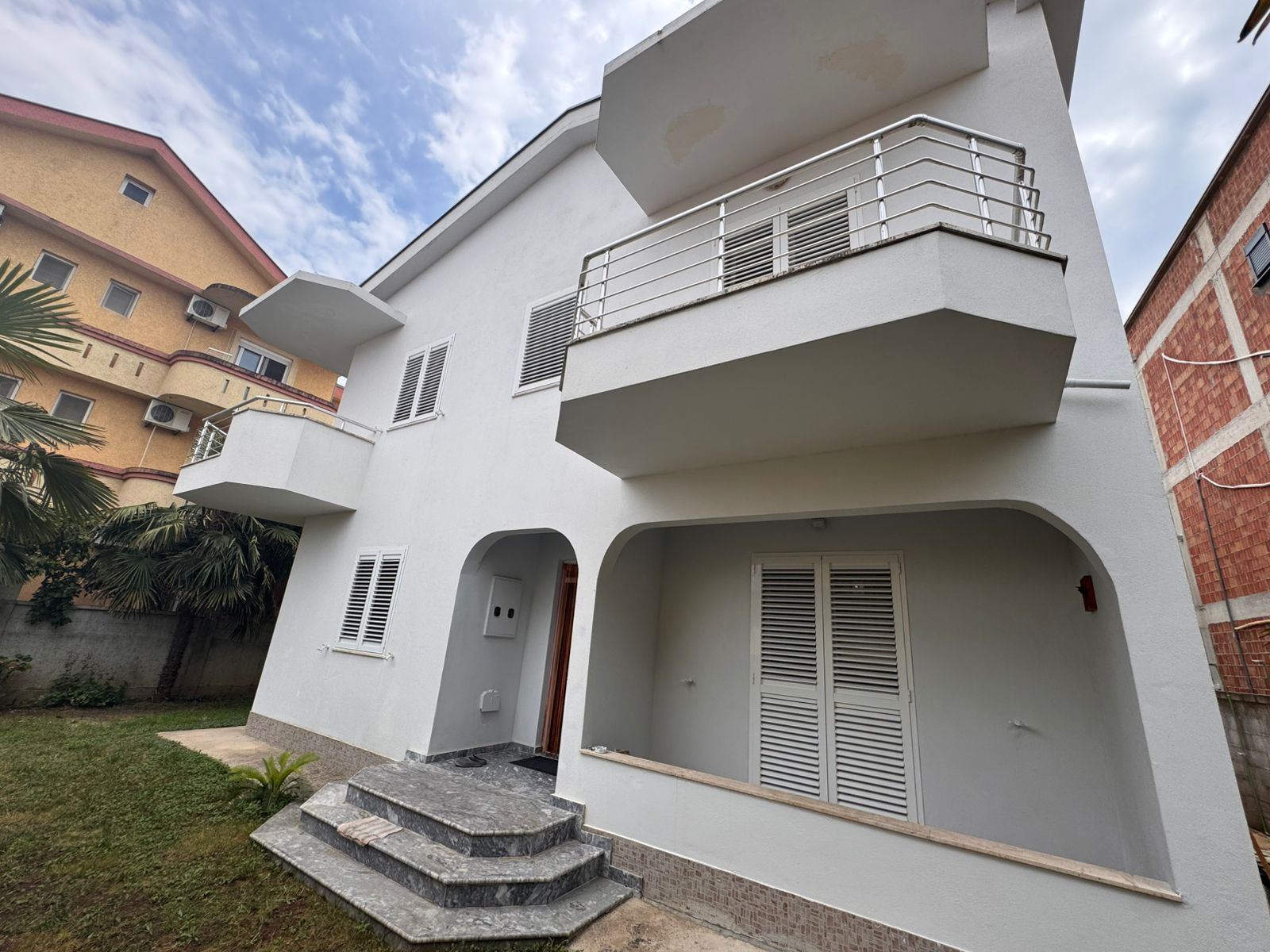 Modern two-story white house in Ulcinj, Montenegro with balconies and lush yard&mdash;exclusive by ekosphere doo on immobilien.ekosphere.me.