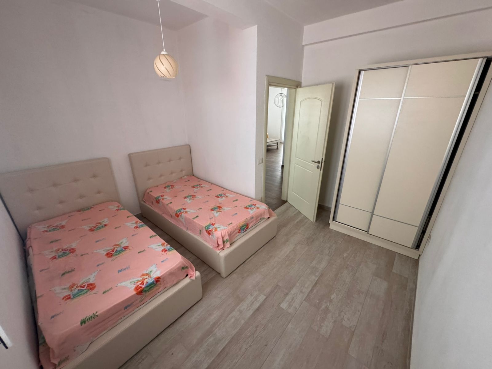 Ulcinj real estate gem: bright bedroom with twin beds, stylish wardrobe, and wood floors. Ekosphere quality&mdash;immobilien.ekosphere.me project.