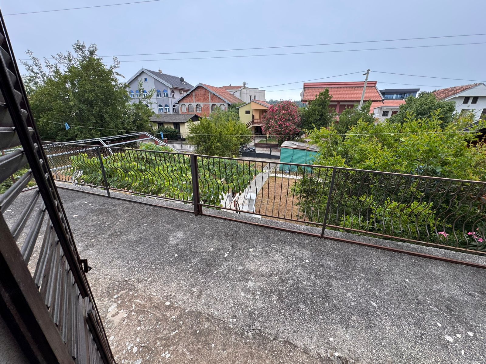 Stunning balcony view over lush fenced garden, sheds & prime Ulcinj properties&mdash;exclusive at immobilien.ekosphere.me by Ekosphere doo.