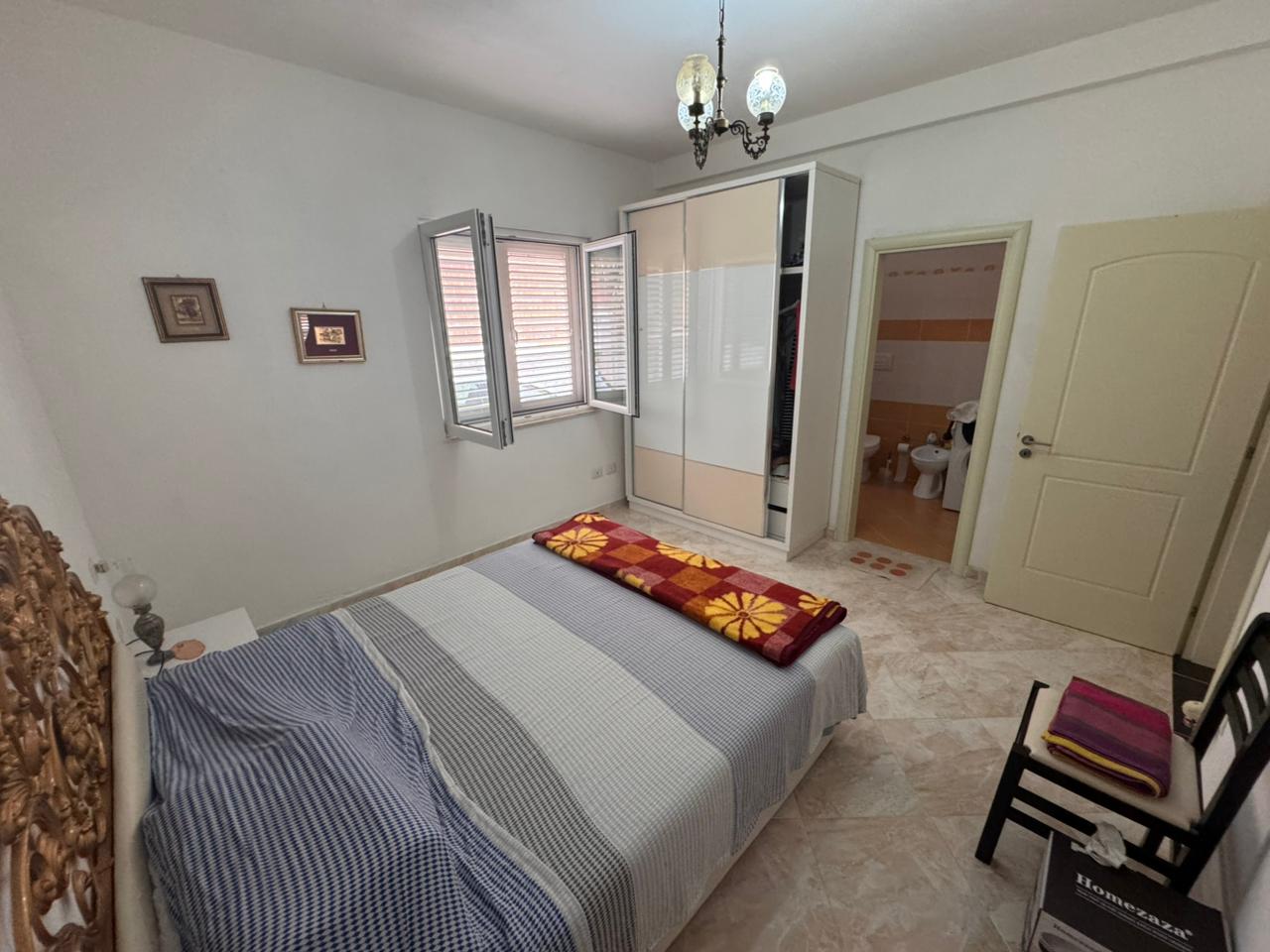 Modern Ulcinj bedroom with double bed, chic wardrobe, and sunny windows&mdash;ideal eco-real estate. Listed by immobilien.ekosphere.me/Ekosphere.