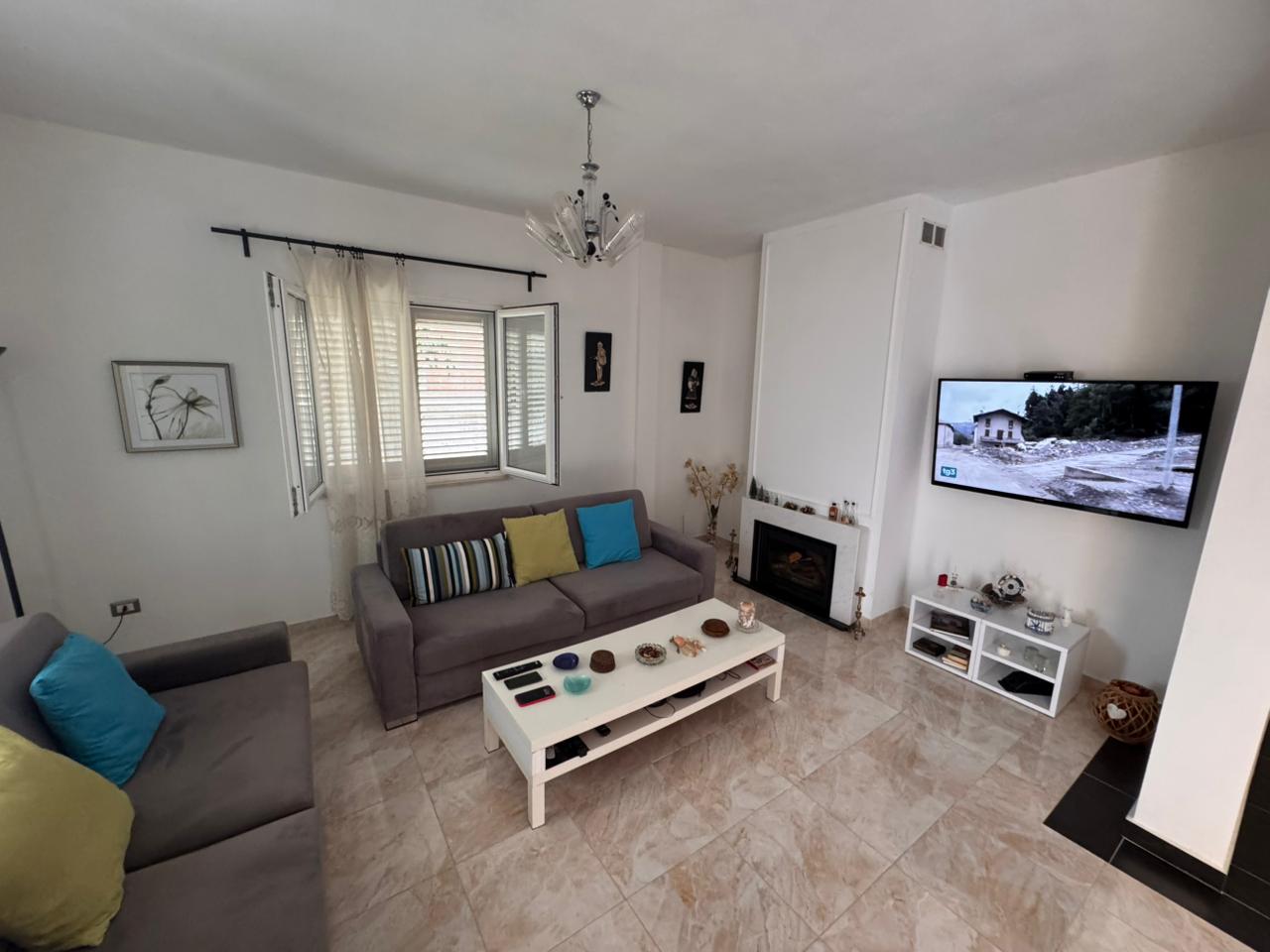 Stylish Ulcinj living room with gray sofas, fireplace, natural light&mdash;prime Montenegro investment via immobilien.ekosphere.me by Ekosphere.