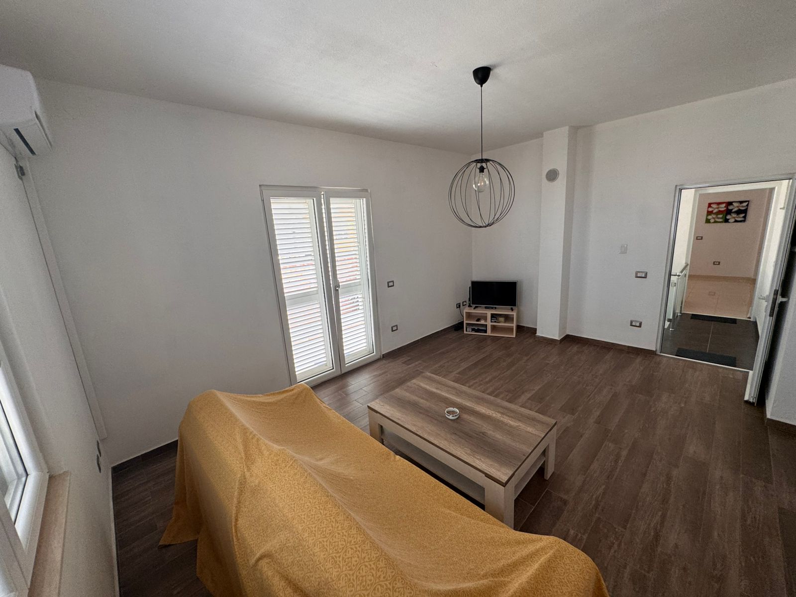 Bright Ulcinj living room with wood floors, large windows, and modern features&mdash;exclusive from Ekosphere at immobilien.ekosphere.me.