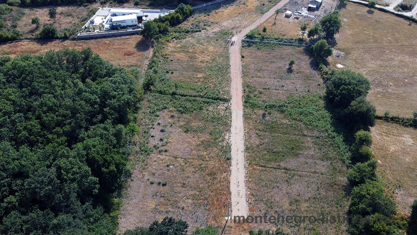 Aerial view of Ulcinj, Montenegro real estate&mdash;lush fields, scenic road, investment properties. By ekosphere doo on immobilien.ekosphere.me.