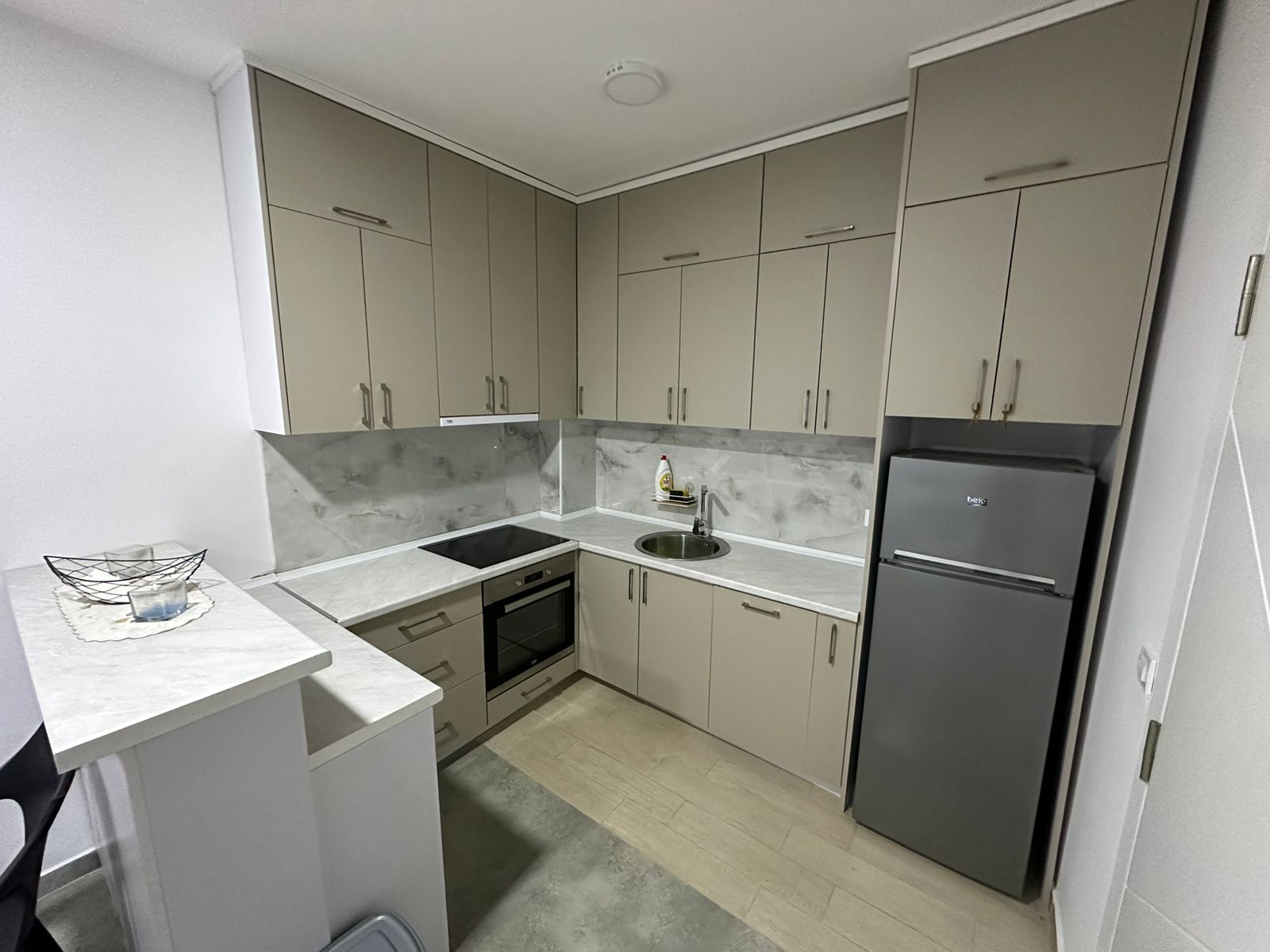 All Listings for Ulcinj: Elegant Ulcinj kitchen for sale: beige cabinets, built-in oven, stainless sink, modern appliances. Listed via immobilien.ekosphere.me by ekosphere doo.