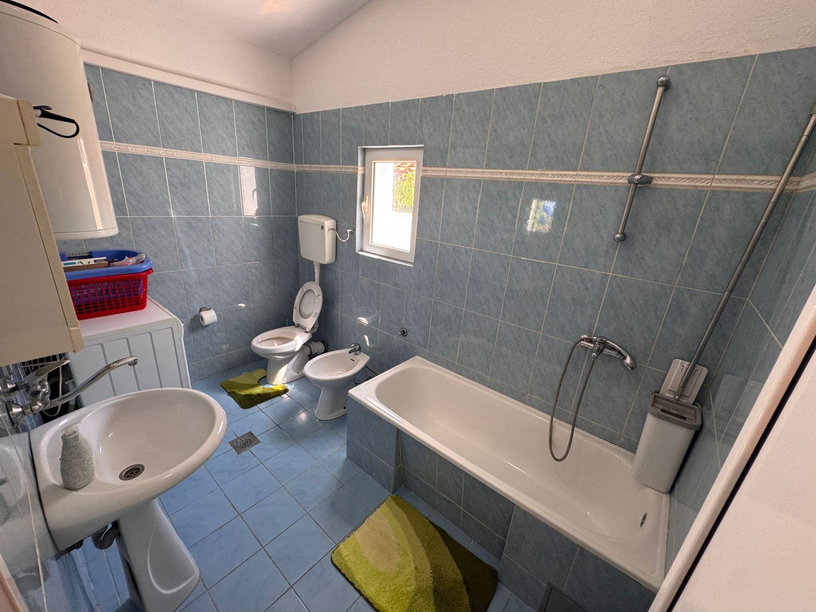 Modern bathroom in Ulcinj, Montenegro: blue tile, tub, bidet, washer & window. Smart investment&acirc;find it on immobilien.ekosphere.me by ekosphere doo.