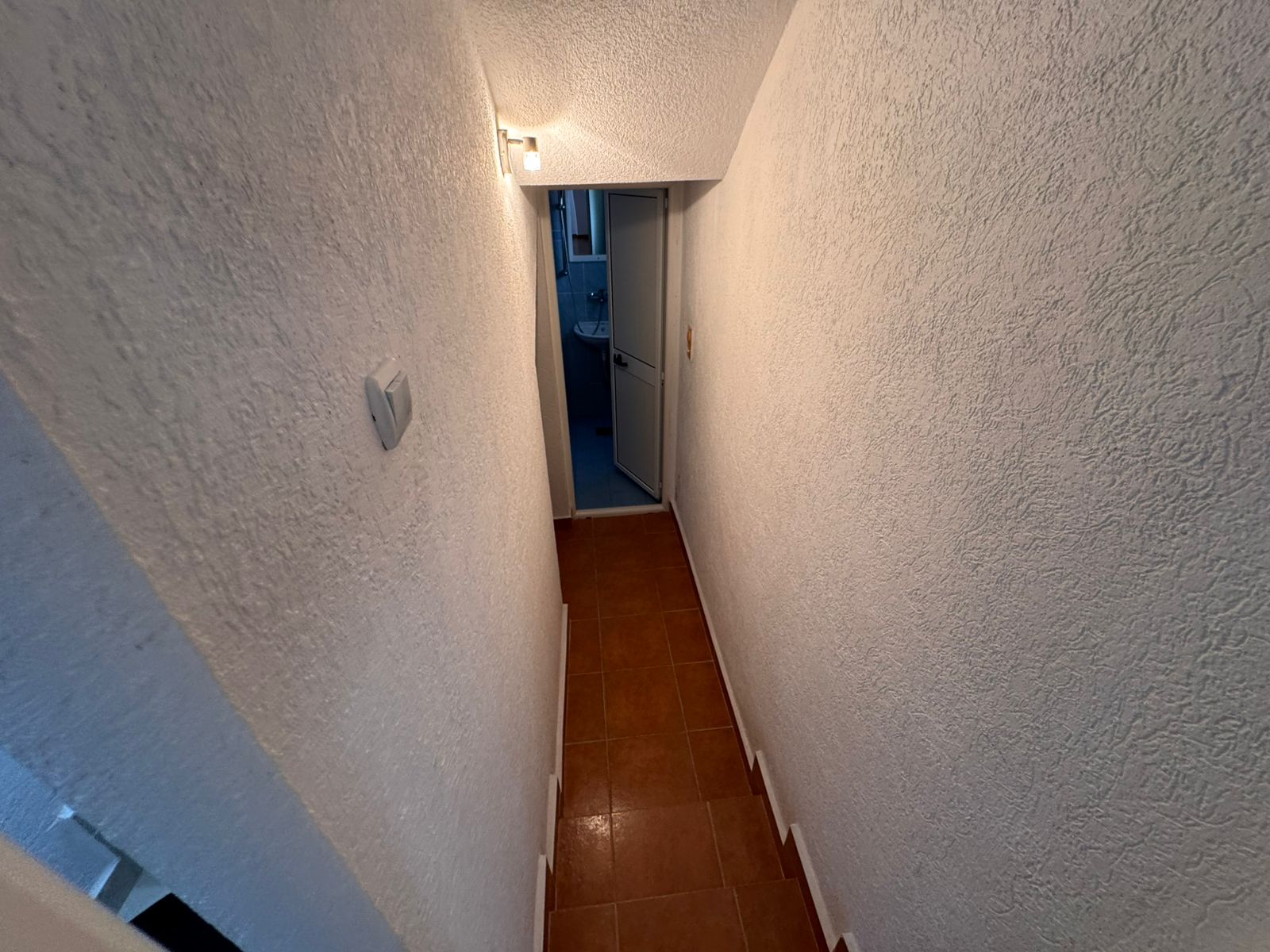 Inviting hallway with textured white walls, tiled floor, and modern lighting&acirc;prime Ulcinj real estate from immobilien.ekosphere.me by ekosphere doo.