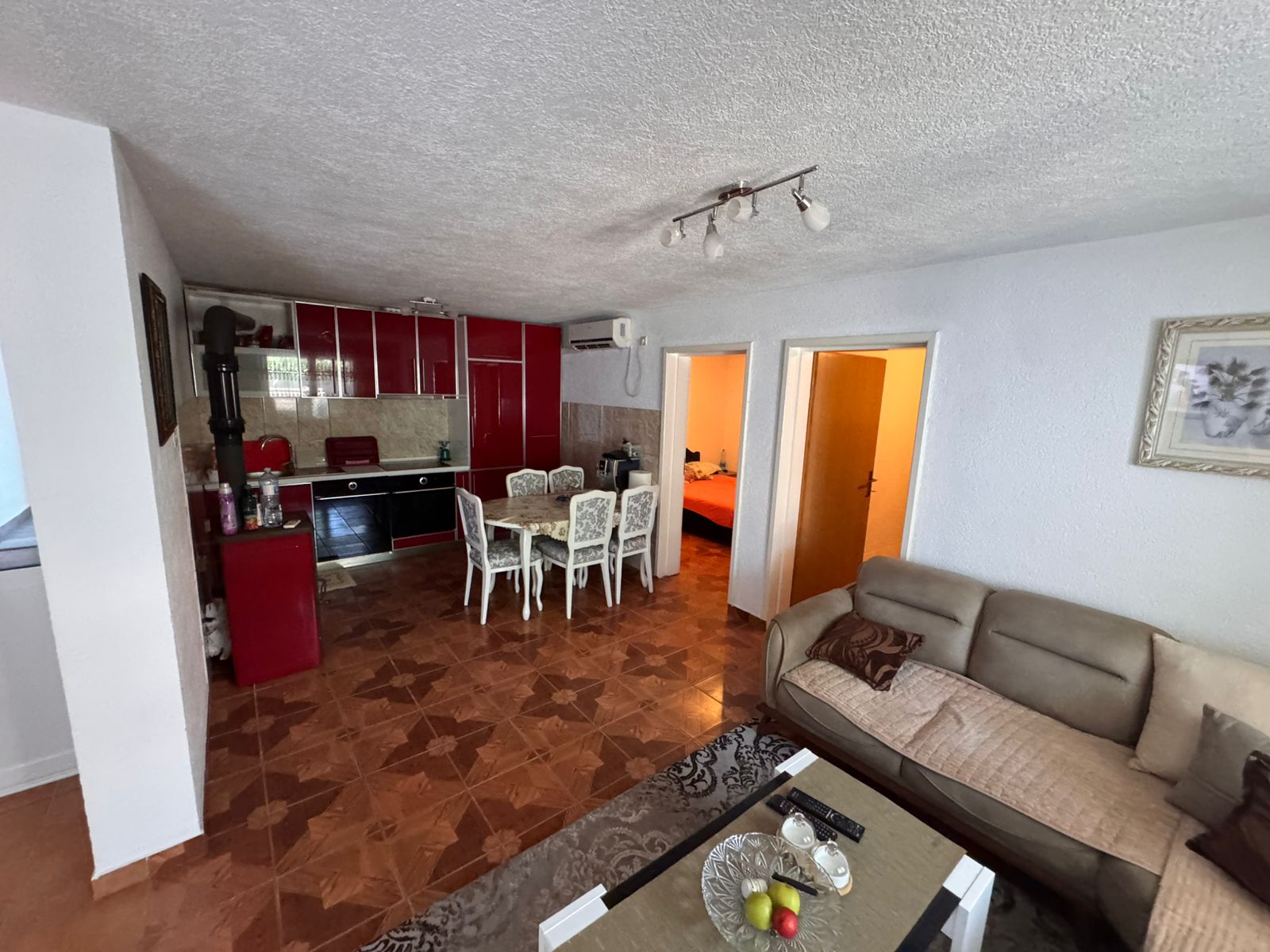 Modern Ulcinj apartment: beige sofa, stylish coffee table, open-plan kitchen with red cabinets, spacious dining&acirc;exclusive on immobilien.ekosphere.me by ekosphere doo.