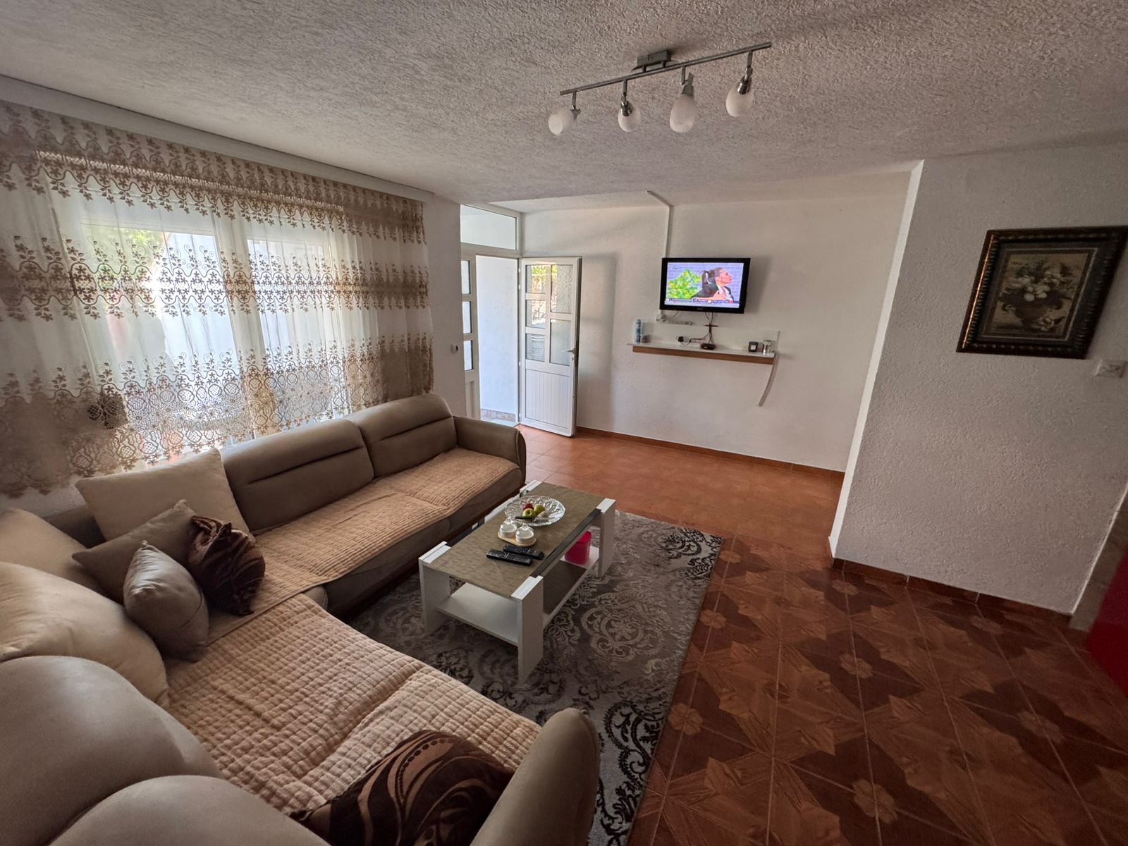 Elegant Ulcinj living room with beige sectional, chic decor, and modern TV&acirc;exclusive on immobilien.ekosphere.me by Ekosphere doo.