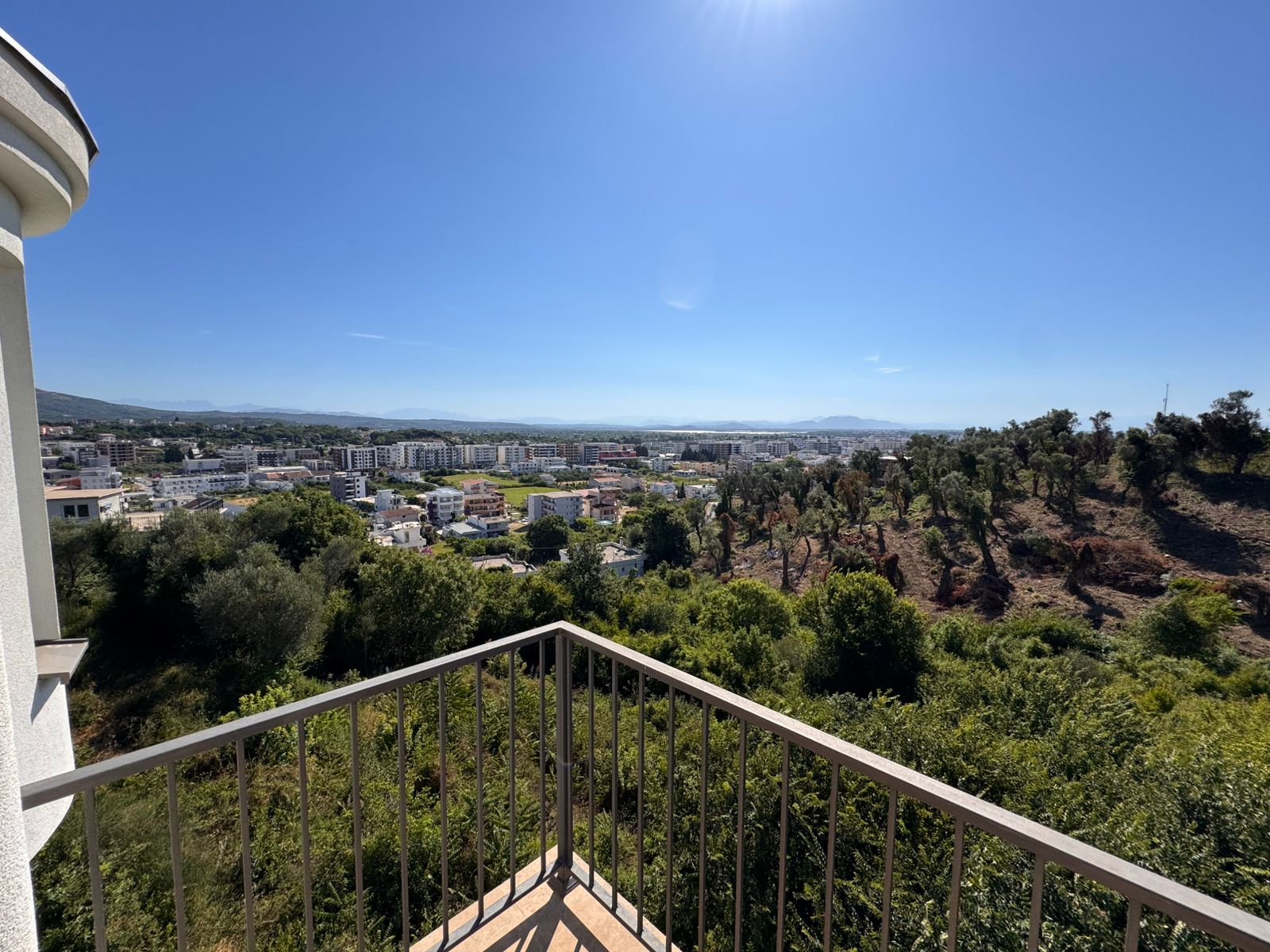Prime balcony view of Ulcinj, Montenegro&mdash;lush hills, cityscape, sunlit skies. Invest via immobilien.ekosphere.me by Ekosphere doo.